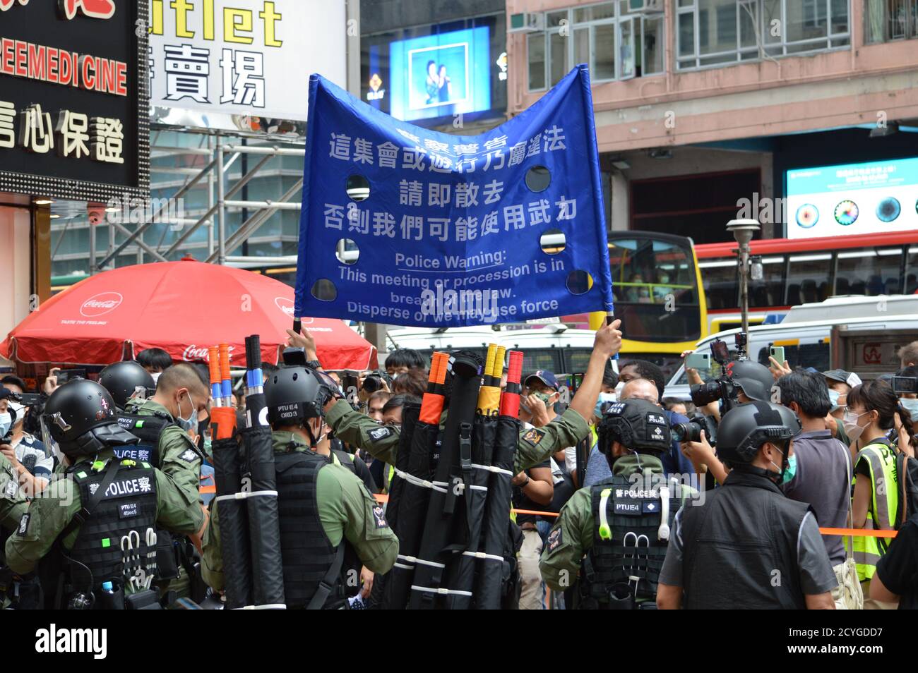 A Hong Kong Police Force officer holds a warning banner aloft in the Causeway Bay shopping district on National Day, October 1, 2020 Stock Photo