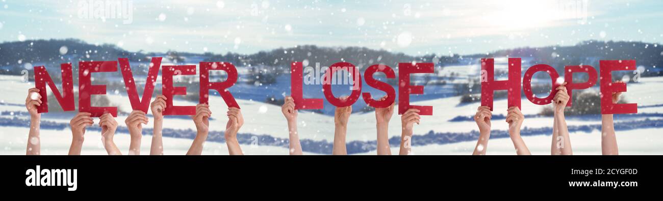 People Hands Holding Word Never Lose Hope, Snowy Winter Background Stock Photo