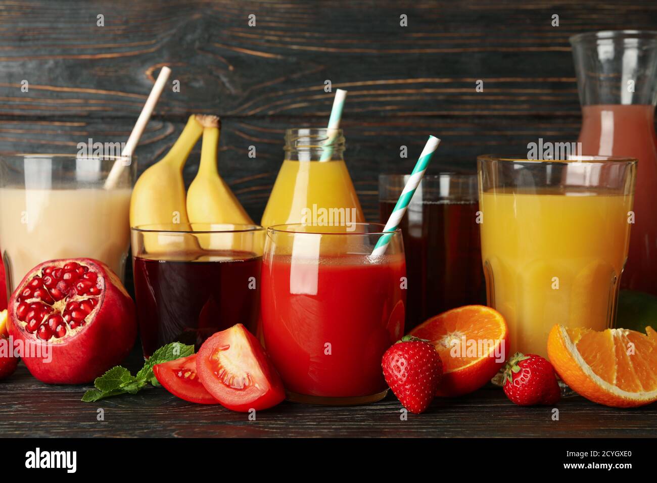 Glasses and jars with different juices on wooden background Stock Photo