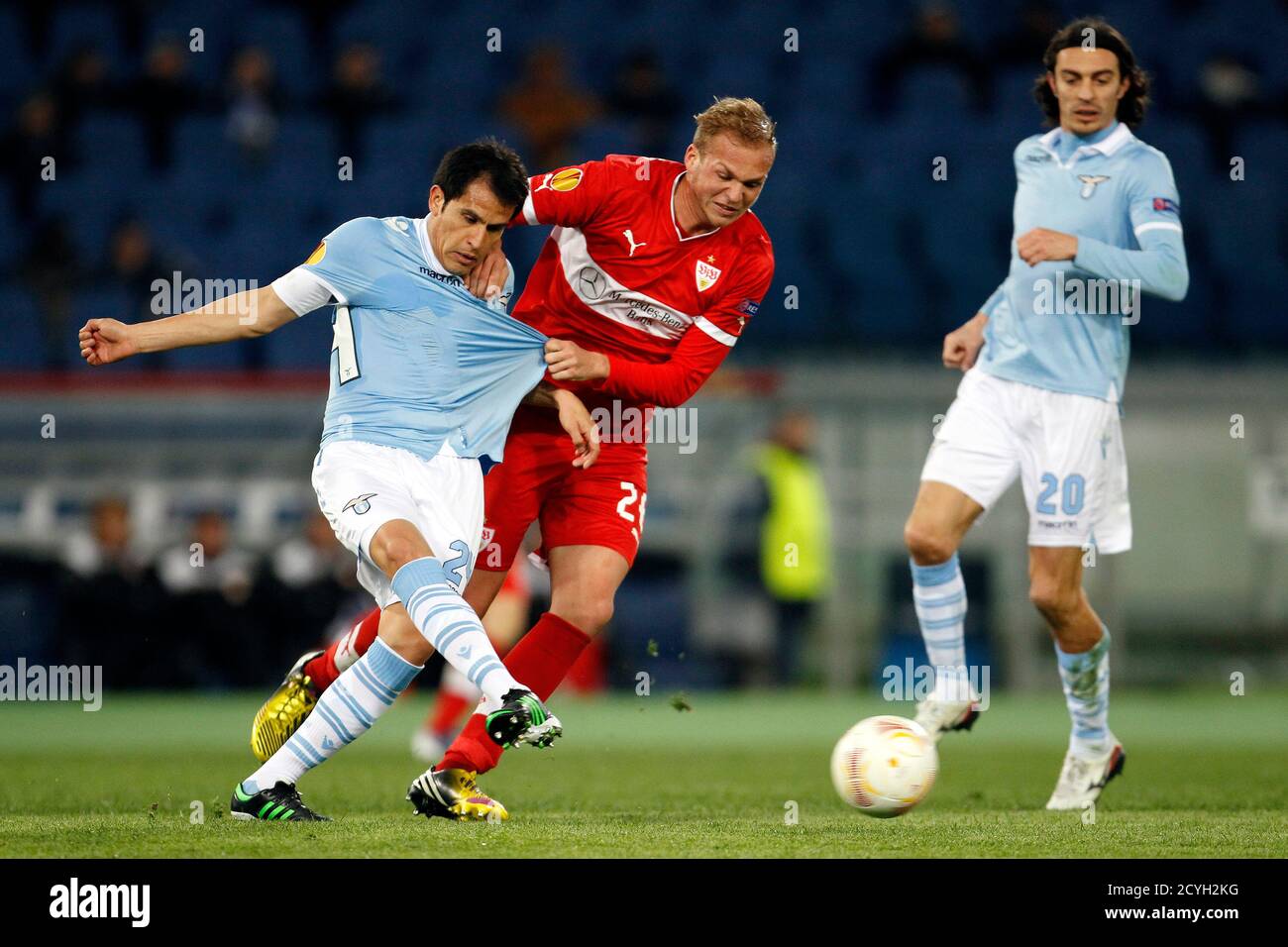 VfB Stuttgart's Raphael Holzhauser (C) challenges Lazio's Cristian Ledesma (L) as Giuseppe Biava (R) watches during their Europa League soccer match at the Olympic stadium in Rome March 14, 2013. REUTERS/Giampiero Sposito (ITALY - Tags: SPORT SOCCER) Stock Photo