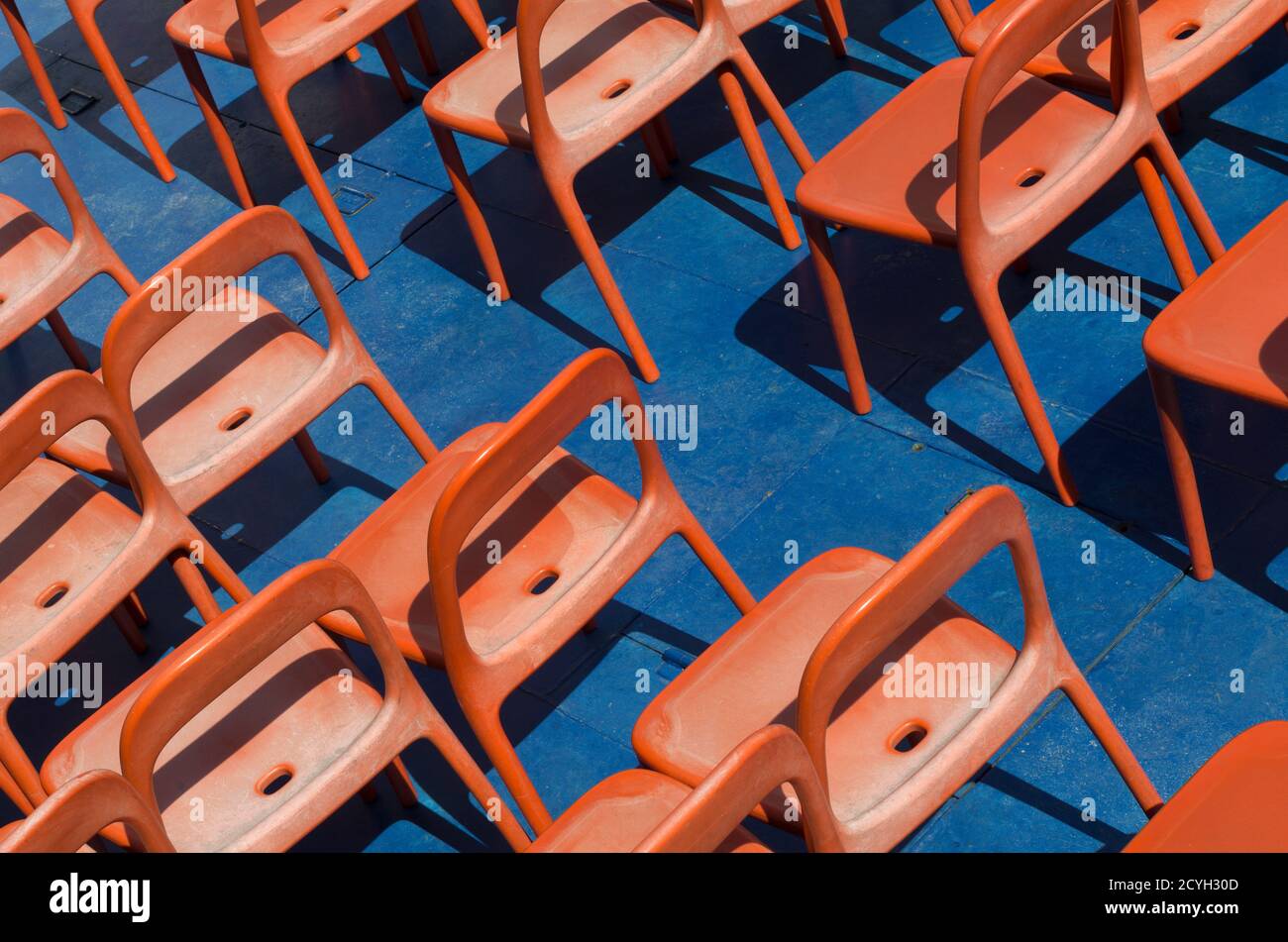 Diagonal photo with orange chairs for tourists illuminated by the sun Stock Photo