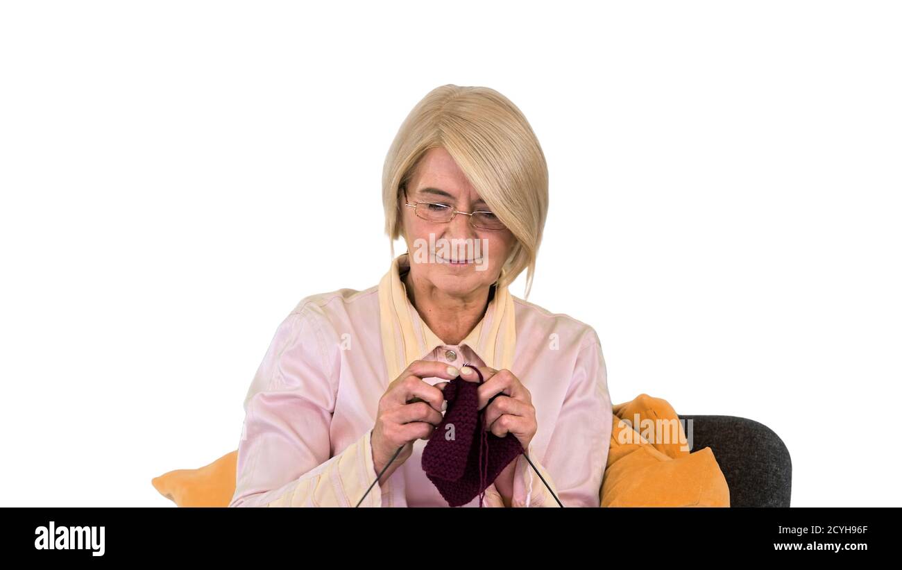 Senior lady knitting sitting on a chair on white background Stock Photo ...