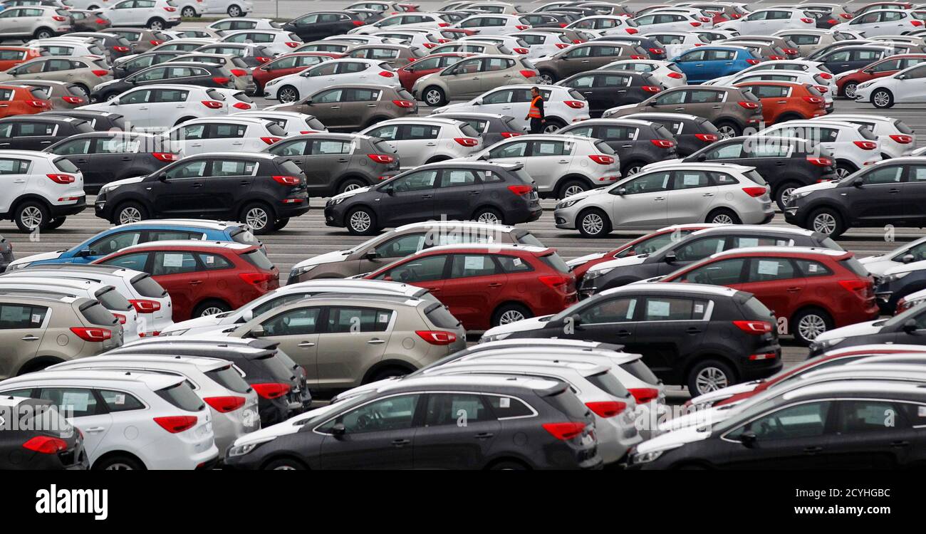A worker walks through a parking lot of Kia cars ready for shipping, in its factory in Zilina, 200 kilometres north of Bratislava October 3, 2012. Carmakers that cut costs last decade in Western Europe like Volkswagen, or those who were never saddled with expensive factories there, such as Korea's Hyundai and Kia, are now investing in new designs, conquering new markets and ramping up production. Between them, VW Group, Mercedes, Kia and Hyundai have raised their share of the European market to 35.5 percent in the eight months to end August 2012, from 30 percent in the same period of 2010. Up  Stock Photo