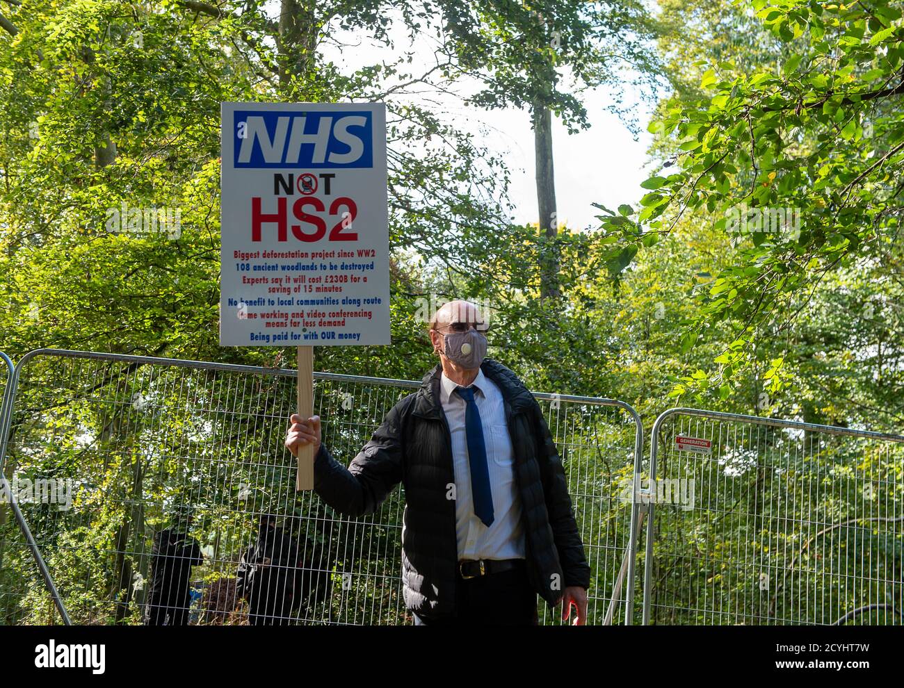 Wendover, UK. 1st October, 2020. A protester holds up an NHS not HS2 sign in the woods. Peaceful tree protectors and environmental campaigners at the Stop HS2 Jones Hill Protection Camp were being evicted today from their homes in the trees by the National Eviction Team Enforcement Agents working on behalf of HS2 Ltd. The over budget and controversial HS2 High Speed Rail link from London to Birmingham project puts 108 ancient woodlands, 693 wildlife sites and 33 SSSIs at risk of damage or destruction. Credit: Maureen McLean/Alamy Stock Photo