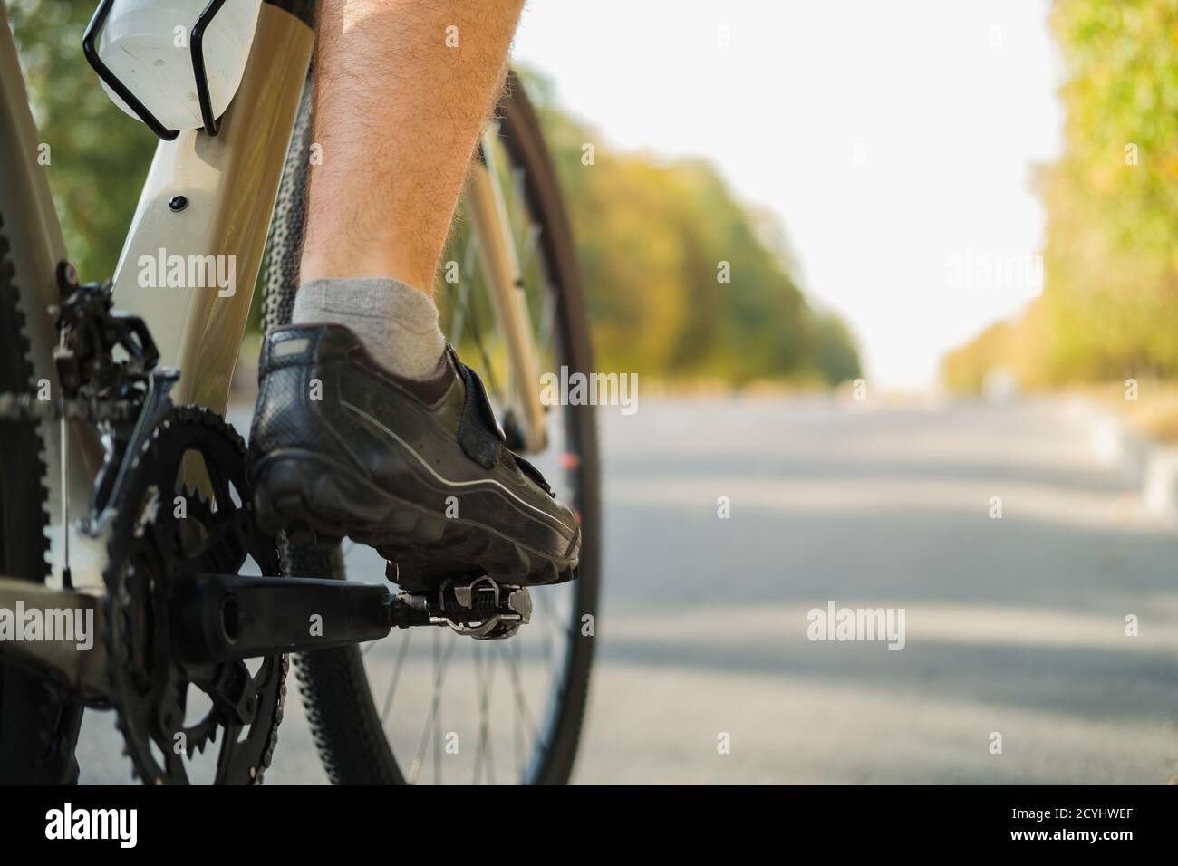 Bicycle shoes with clipless pedals on the crankset, copy space view. Cycling performance, active lifestyle, bike training concept Stock Photo