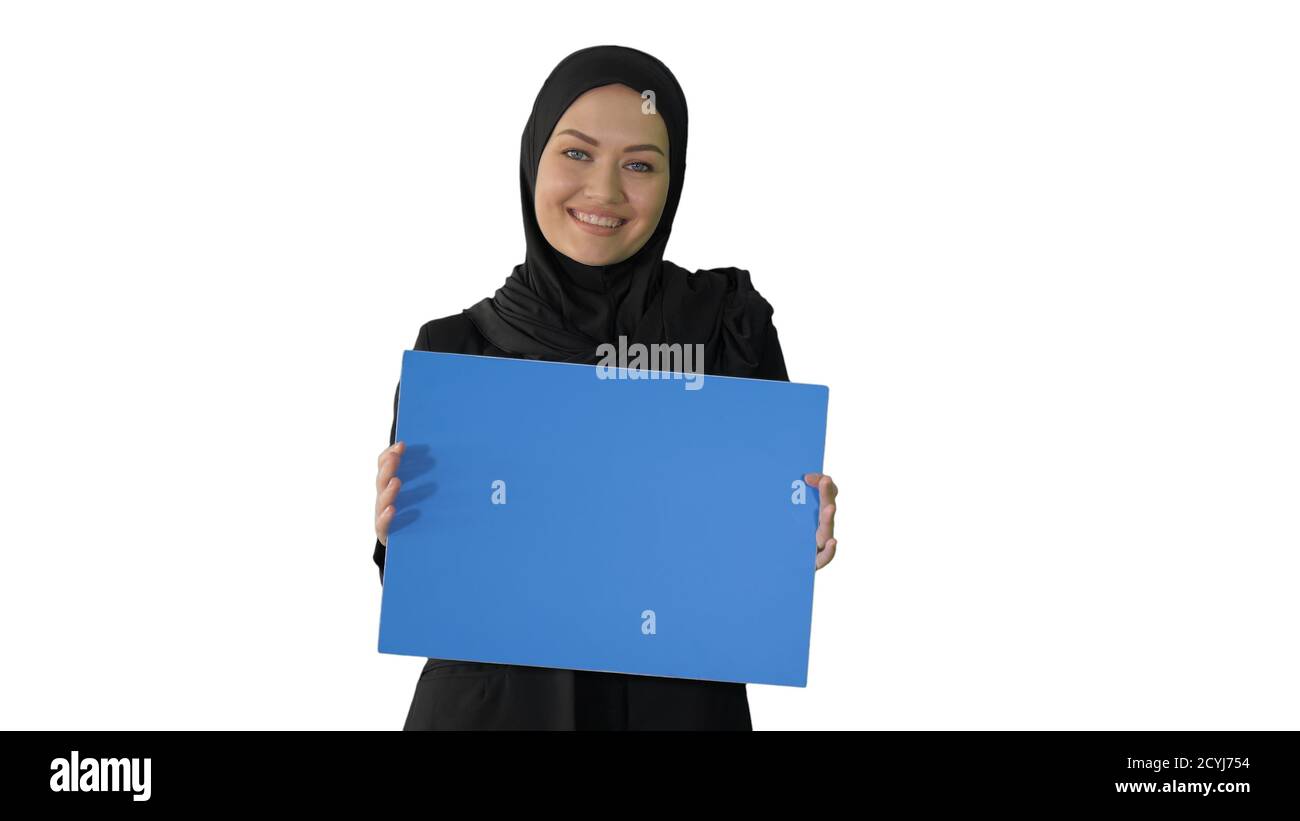Smiling Arab woman in hijab holding blank blue poster and lookin Stock ...