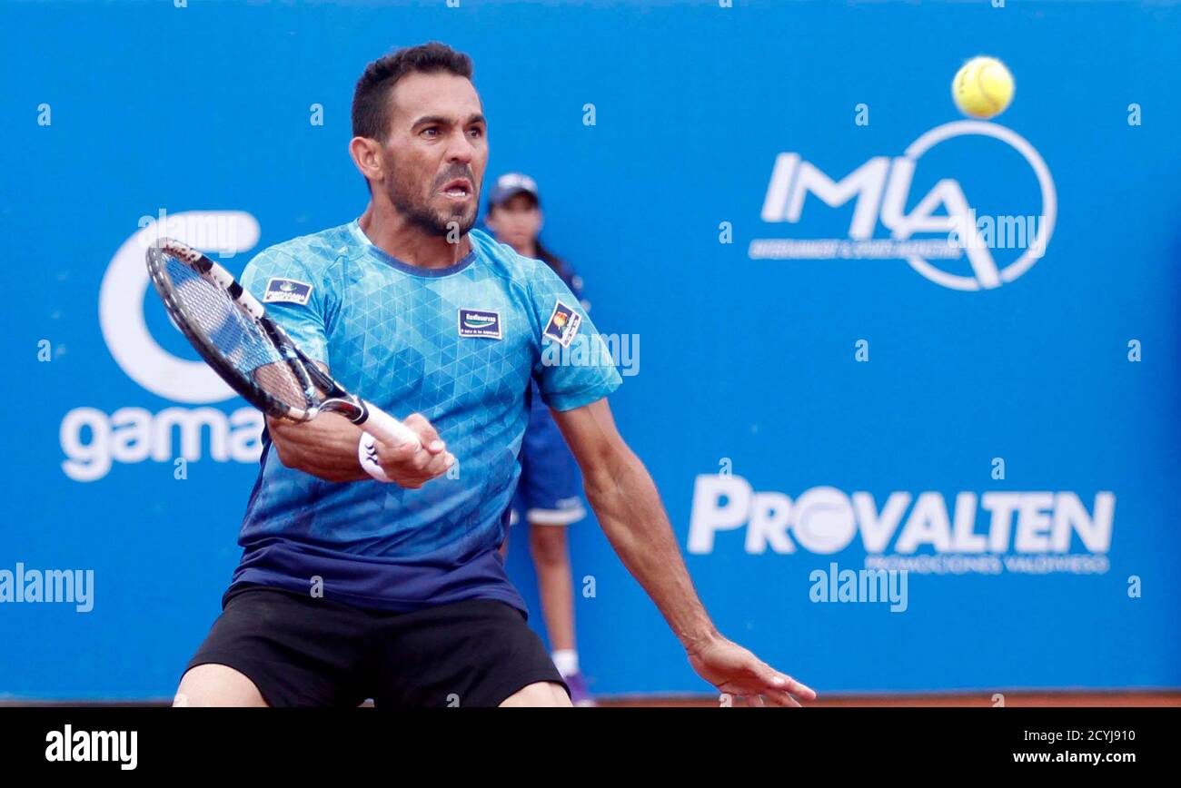 Victor Estrella Burgos of the Dominican Republic hits a shot to Feliciano  Lopez of Spain during their Ecuador Open men's singles final tennis match  at the Jacaranda Club in Cumbaya February 8,