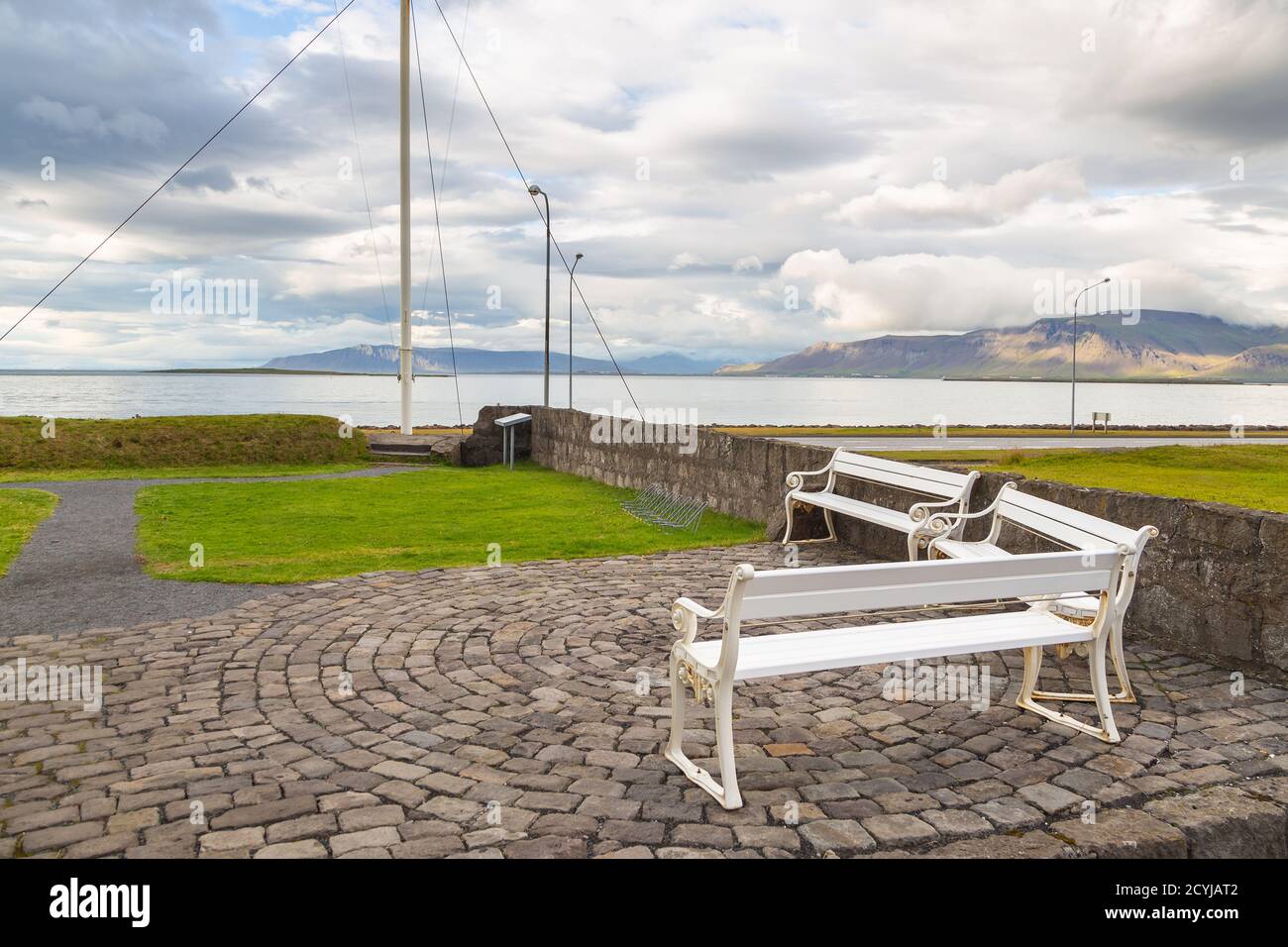 White benches in the square. View of Faxafloi bay and mountains