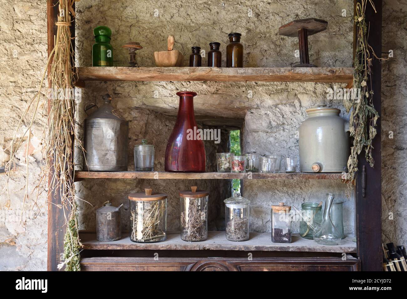 Display of Vintage Glassware and Old Bottles on Old Rustic Wooden Shelves in Colmars or Colmars-les-Alpes Museum France Stock Photo