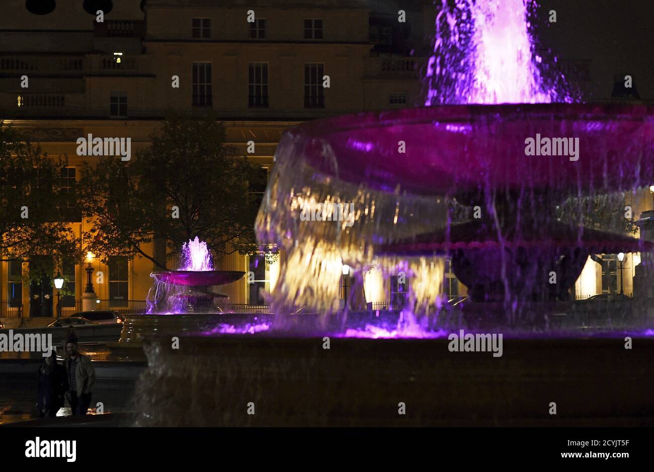 A couple stroll through Trafalgar Square past pink coloured fountains, as  part of celebrations after the royal birth in London, Britain, May 2, 2015.  Britain's Duchess of Cambridge, the wife of Prince