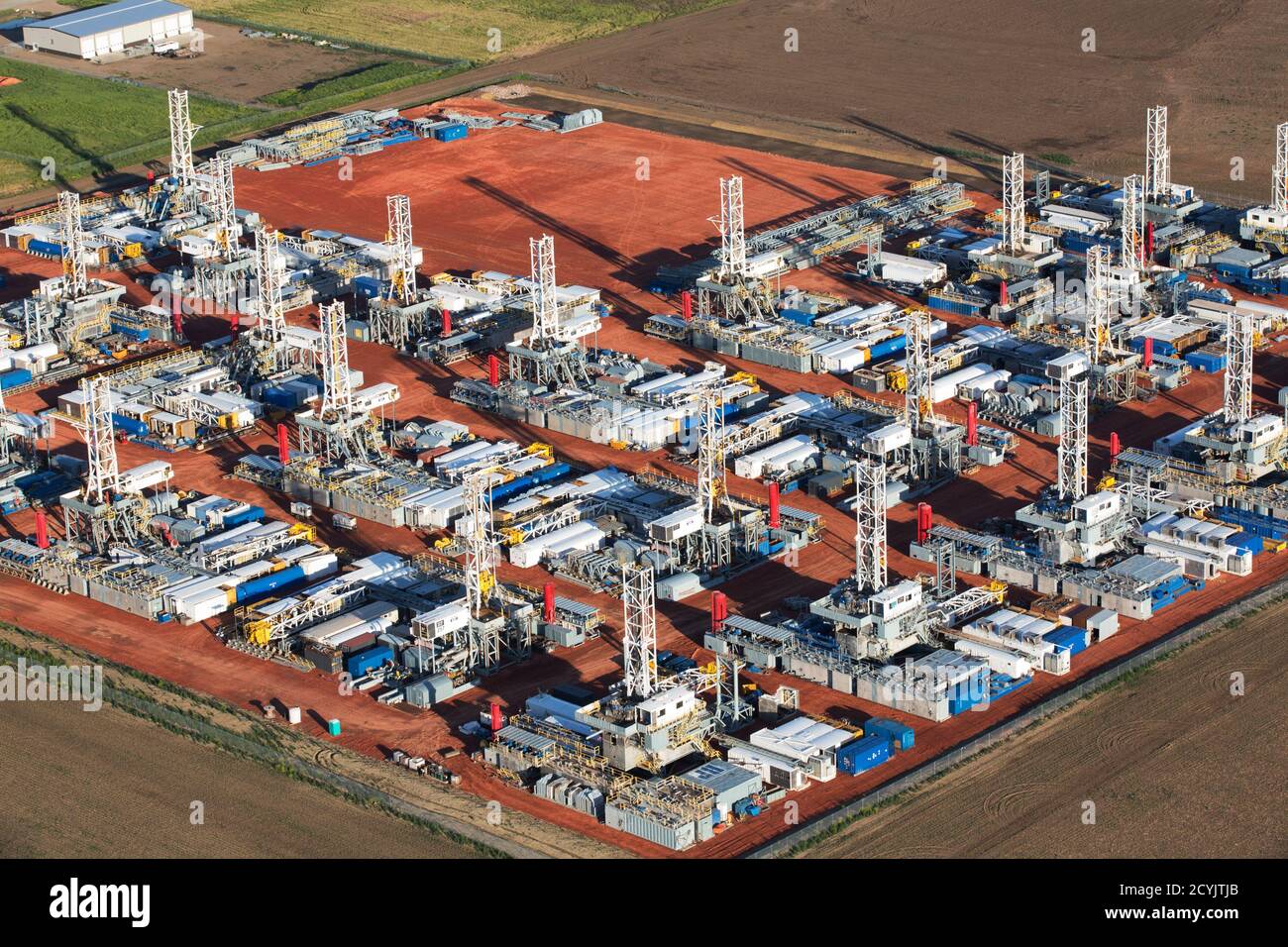 Stacked rigs are seen along with other idled oil drilling equipment at a depot in Dickinson, North Dakota June 26, 2015. Since November, the Saudi Arabian-led OPEC cartel has held to a policy of unconstrained output, an approach many suspect is designed to flood global markets with more crude, push prices lower and punish rivals, including North Dakota, the second-largest U.S. oil producer.  REUTERS/Andrew Cullen Stock Photo