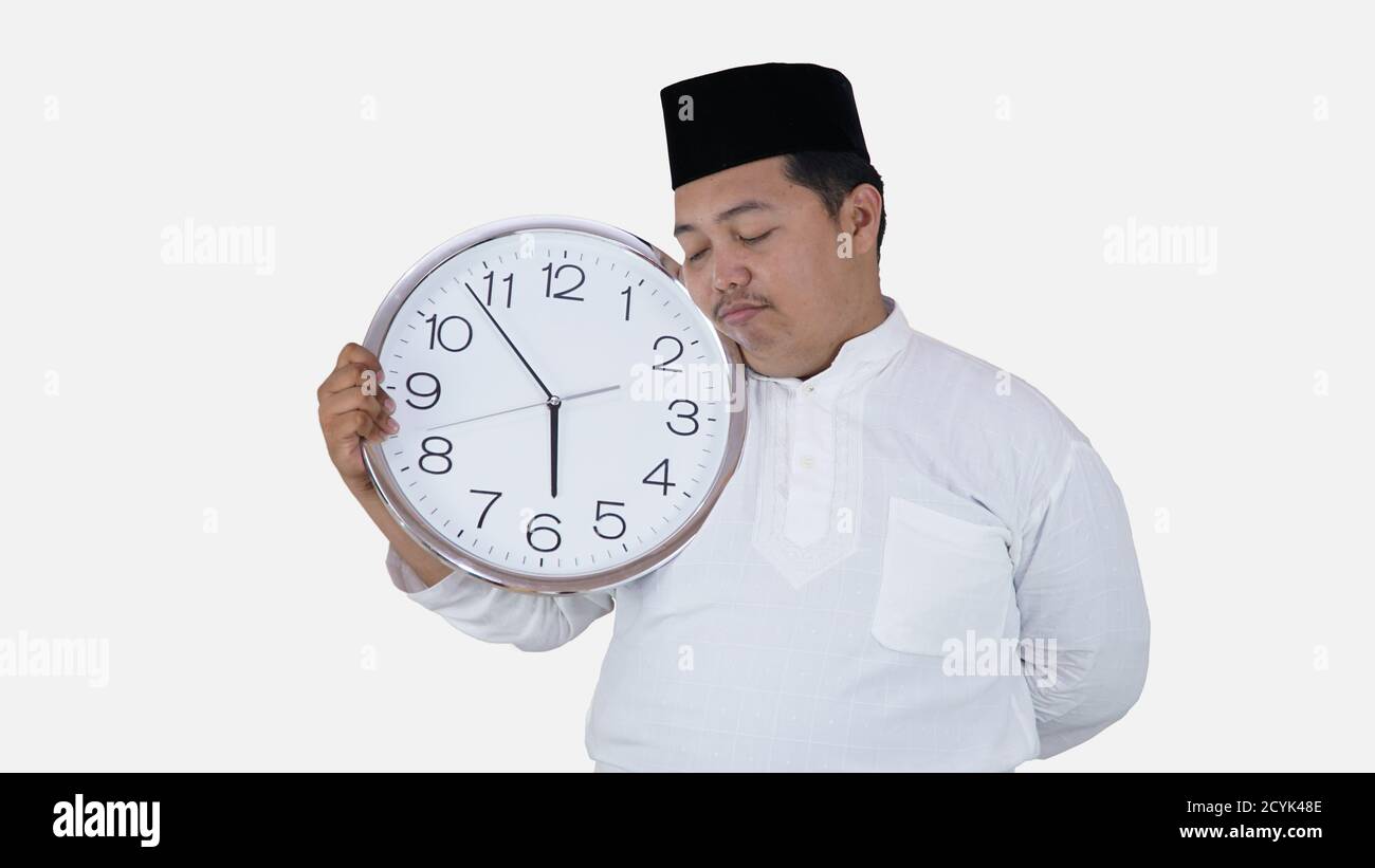 muslim asian with overweight standing and holding big round clock waiting for break fasting. islam fat boy can't waiting for muslim break fasting conc Stock Photo