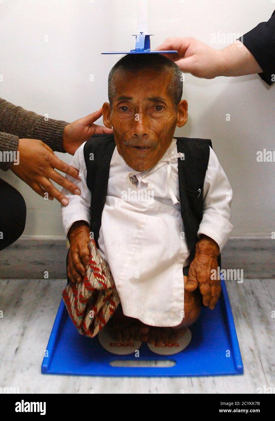 Chandra Bahadur Dangi, 72, who claims to be the world's shortest man  standing at a height of 22 inches (56 centimeters), is measured by the  Editor-in-Chief of Guinness World Record Craig Glenday (