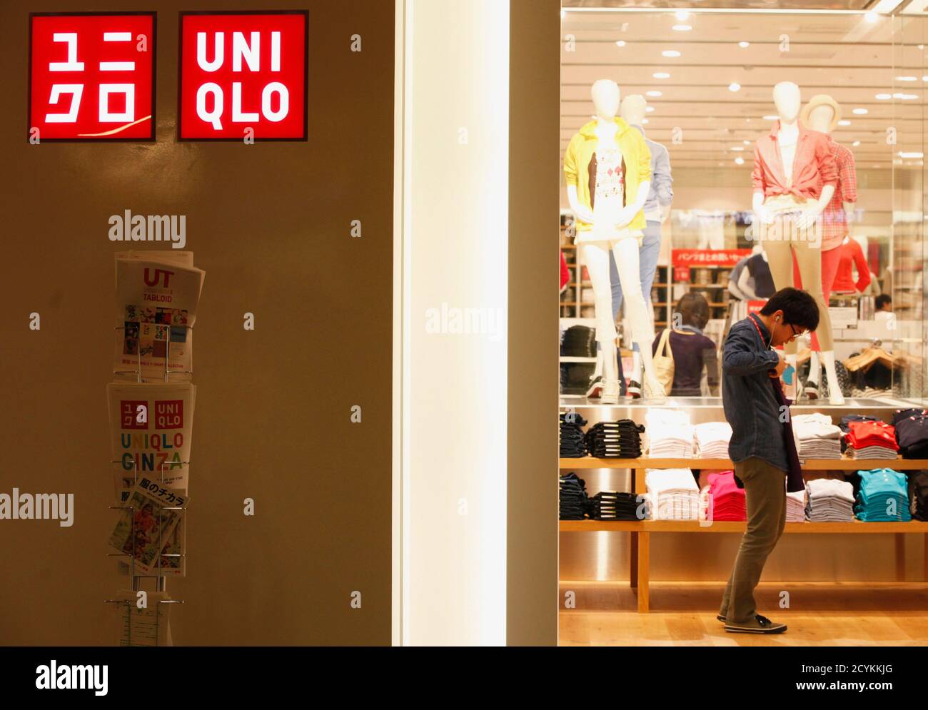 An employee folds a shirt at Fast Retailing Co's Uniqlo clothing chain  store in Tokyo April 12, 2012. Asia's top apparel retailer Fast Retailing  Co lifted its annual profit forecast to a