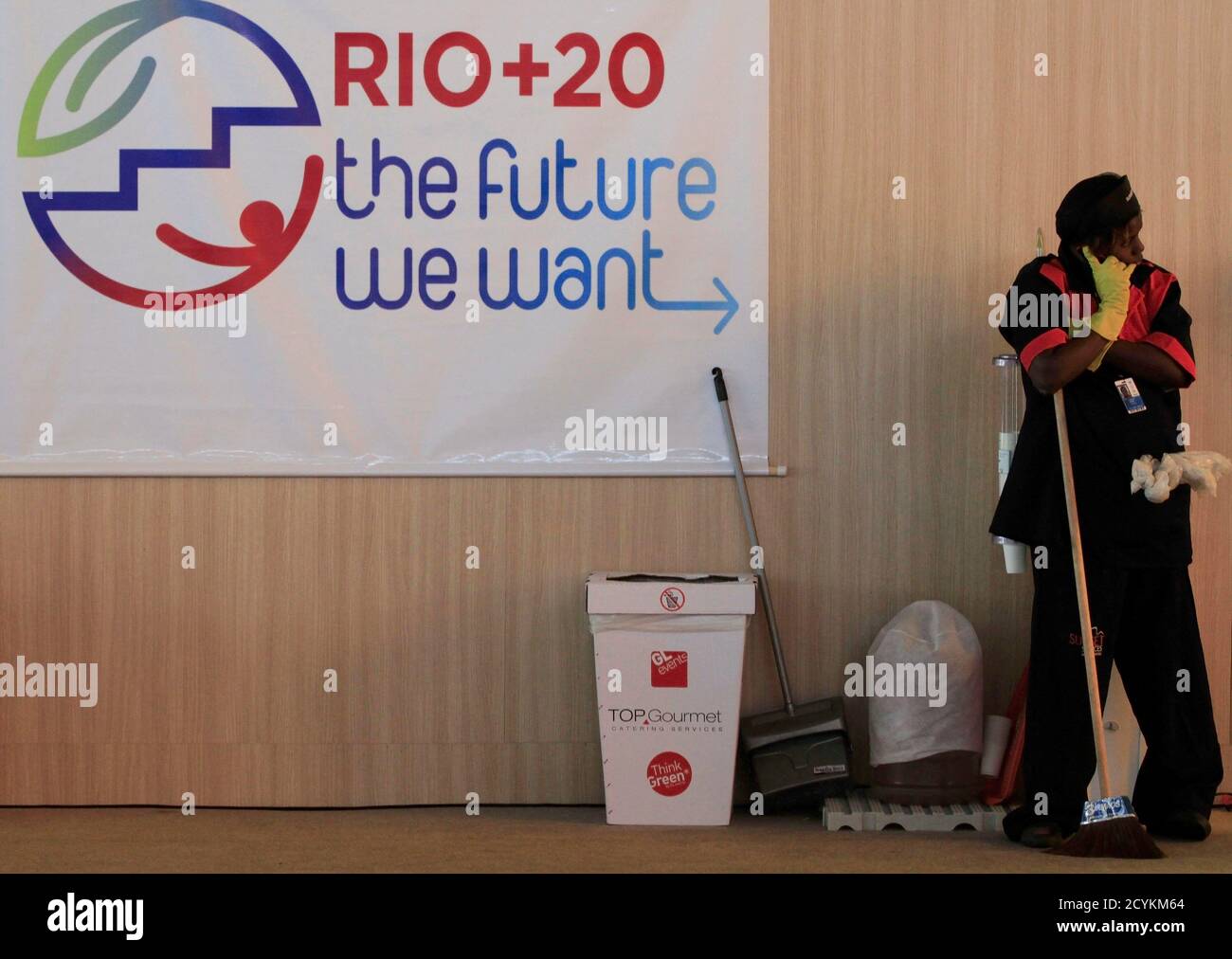 A Worker Talks On Her Mobile Phone During A Break Next To The Logo Of The Rio United Nations Conference On Sustainable Development At The Entrance Of The Brazil Pavilion In
