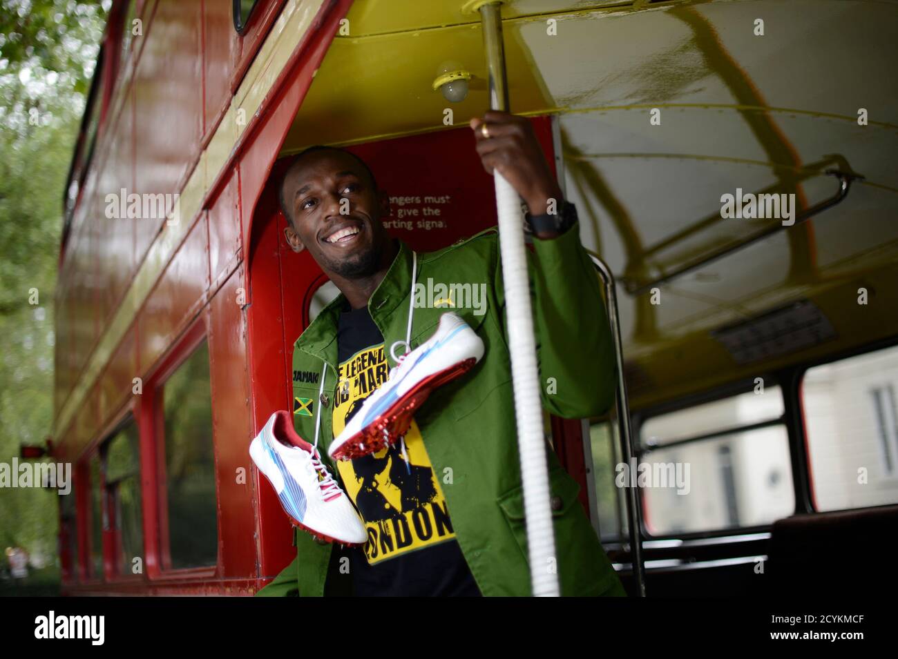 Sprinter Usain Bolt of Jamaica poses with his running spikes and official  team uniform for the London 2012 Olympic Opening Ceremony during a  photoshoot, arranged by his sponsors PUMA, beside a traditional routemaster  bus outside the British Museum ...