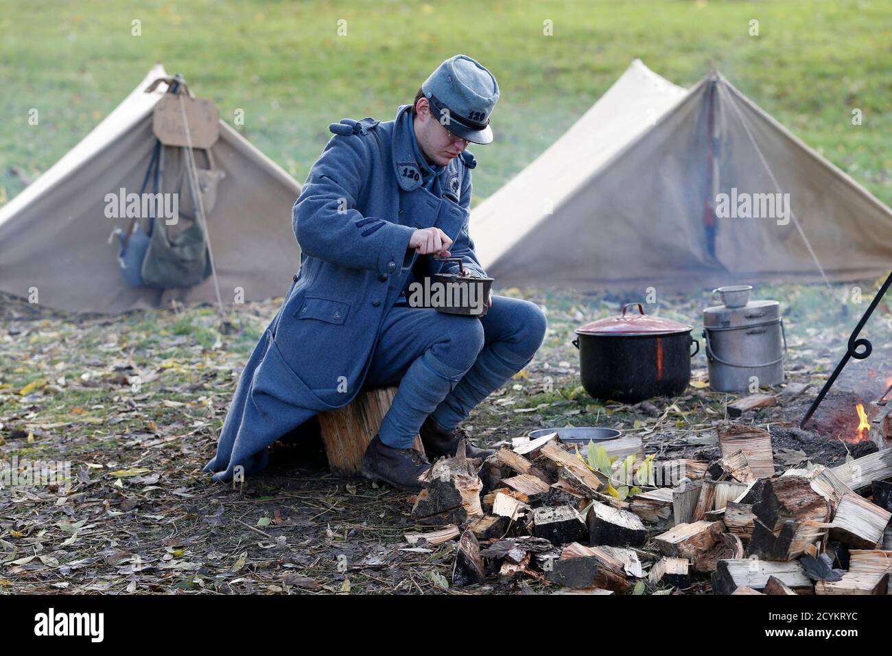 Andy, member of World War One Historical Association '14-18 en Somme', dressed with vintage army uniforms as Poilu (French soldier in World War I) grinds coffee at a bivouac camp in Fouilloy, Northern France, November 10, 2013. The historical association '14-18 en Somme' was created in August 2009 by French history teacher Sylvain Pinard with the aim of keeping alive the memory of the soldiers of World War One, and promoting understanding of the battles of the Great War. Armed with their motto 'Never forget, always remember', the 30 members live, eat and sleep in the same conditions as the sol Stock Photo