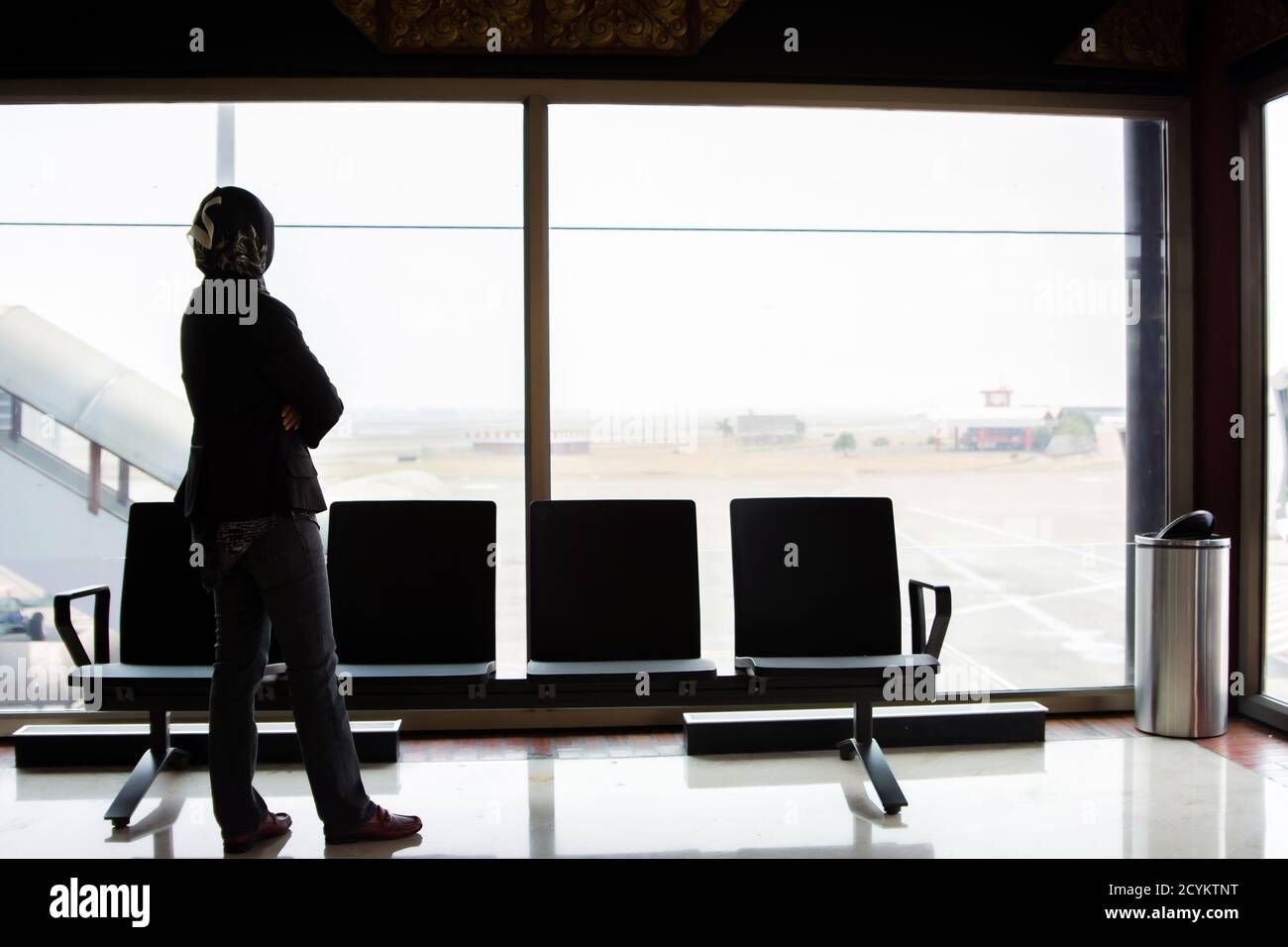 the silhouette of the rear view of a veiled Muslim woman standing in ...