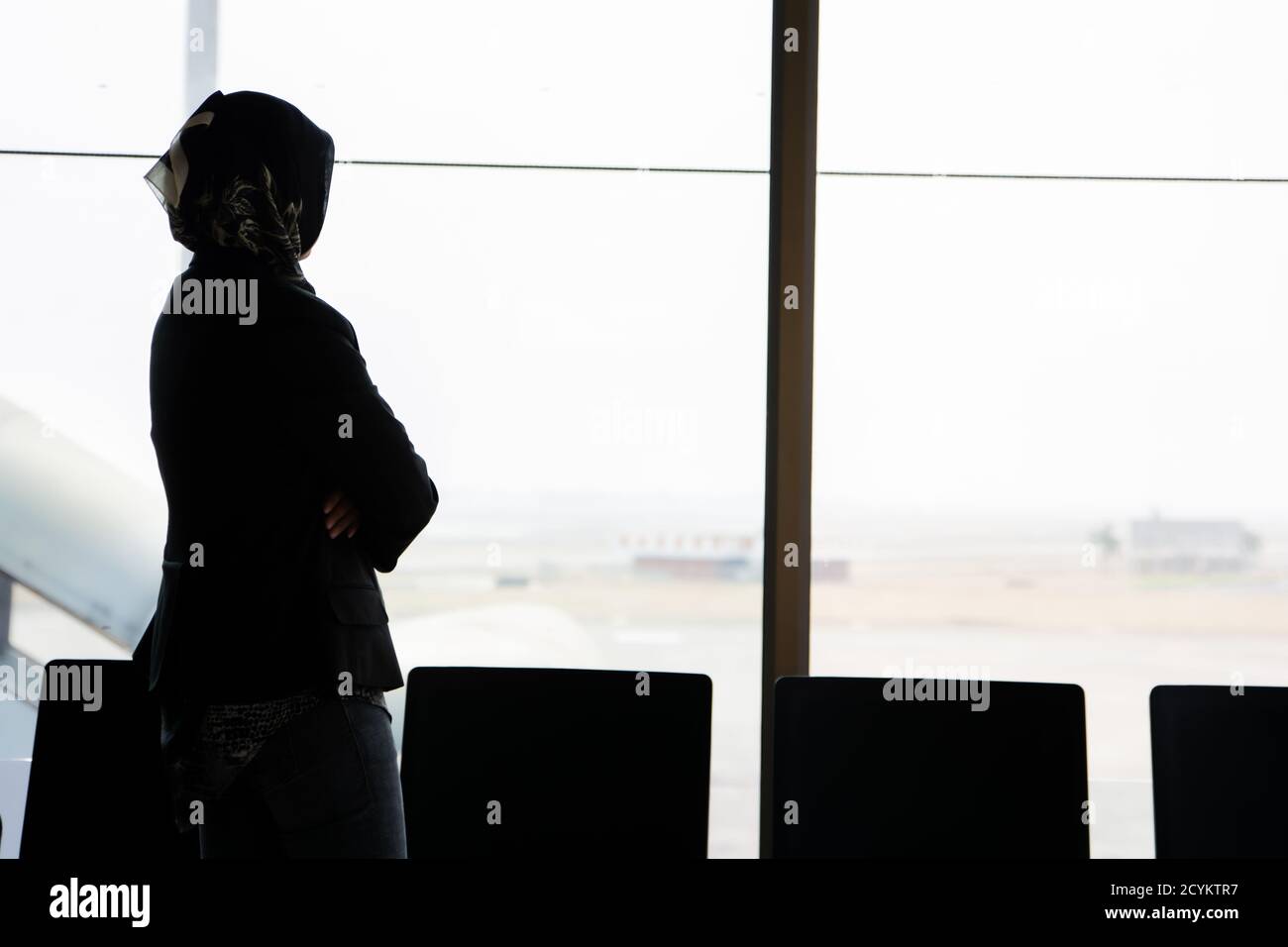 the silhouette of the rear view of a veiled Muslim woman standing in ...