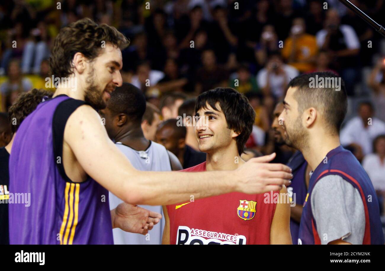 Los Angeles Lakers players Pau Gasol (L) of Spain speaks with Barcelona's  players Juan Carlos Navarro (R) and Ricky Rubio (C) during a practice  session attended by basketball fans in Barcelona October