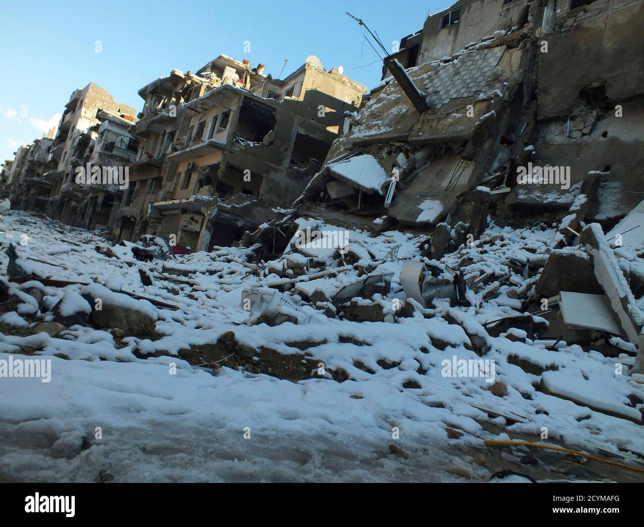 Damaged buildings covered with snow are seen at Jouret al Shayah area in Homs January 10, 2013. Picture taken January 10, 2013. REUTERS/Yazan Homsy (SYRIA - Tags: CONFLICT POLITICS CIVIL UNREST) Stock Photo