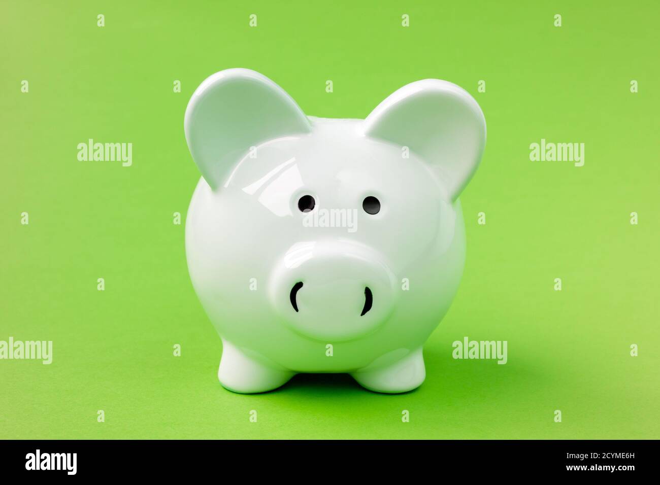 White ceramic piggy bank on the green background Stock Photo - Alamy