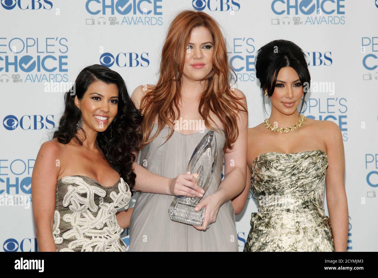Reality television sisters (L-R) Kourtney, Khloe and Kim Kardashian pose with their favorite guilty pleasure award for 'Keeping Up with the Kardashians' at the 2011 People's Choice Awards in Los Angeles January 5, 2011  REUTERS/Danny Moloshok   (UNITED STATES) (PEOPLESCHOICE -BACKSTAGE - Tags: ENTERTAINMENT) Stock Photo