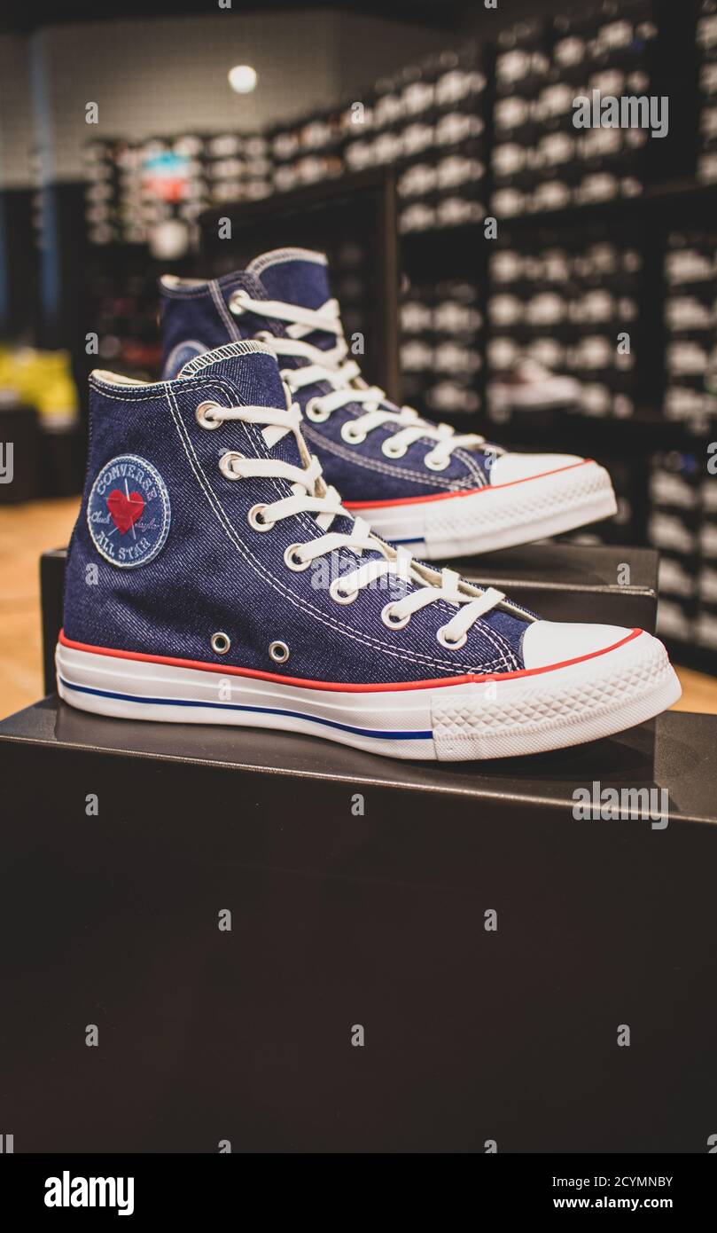 Converse shoes on display. They are an American shoe company that designs and produces sneakers that are cool grungy popular with the youth culture Stock Photo Alamy