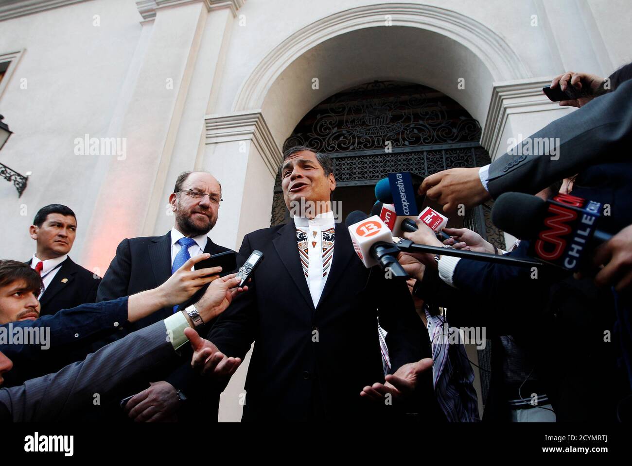 Ecuador's President Rafael Correa (C) speaks to the media, accompanied by  Chile's Foreign Minister Alfredo Moreno Charme (2nd L), inside the  government palace before a meeting with Chile's President Sebastian Pinera  (not