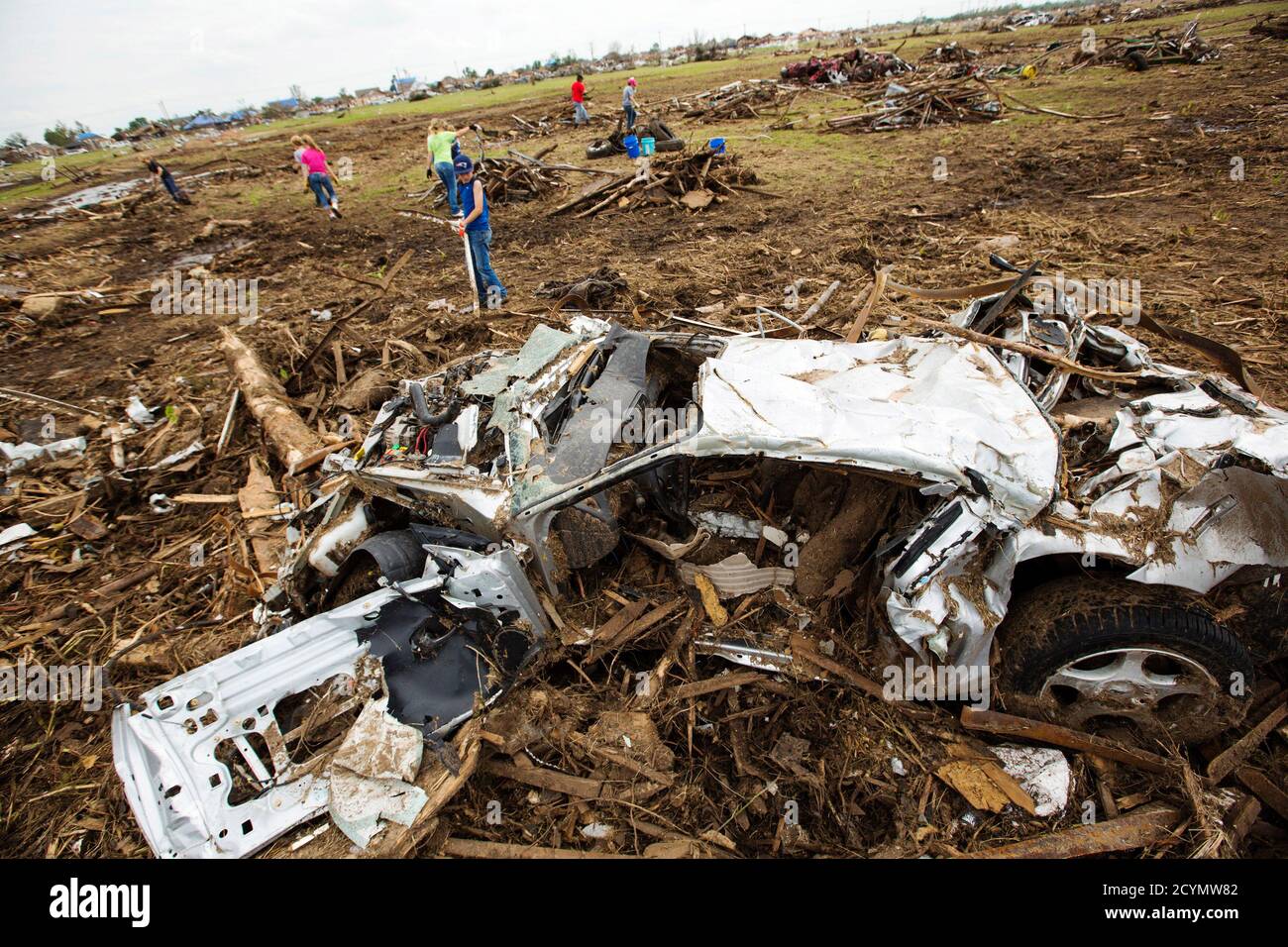 a-wind-damaged-car-rests-near-volunteers-working-to-remove-debris-from-a-field-near-the-orr-family-farm-in-oklahoma-city-oklahoma-may-25-2013-the-tornado-was-the-strongest-in-the-united-states-in-nearly-two-years-and-cut-a-path-of-destruction-17-miles-27-km-long-and-13-2-km-miles-wide-storm-experts-said-it-was-remarkable-that-only-24-people-were-killed-as-tornadoes-of-this-strength-can-blow-away-a-well-constructed-brick-or-wood-house-reuterslucas-jackson-united-states-tags-disaster-environment-2CYMW82.jpg