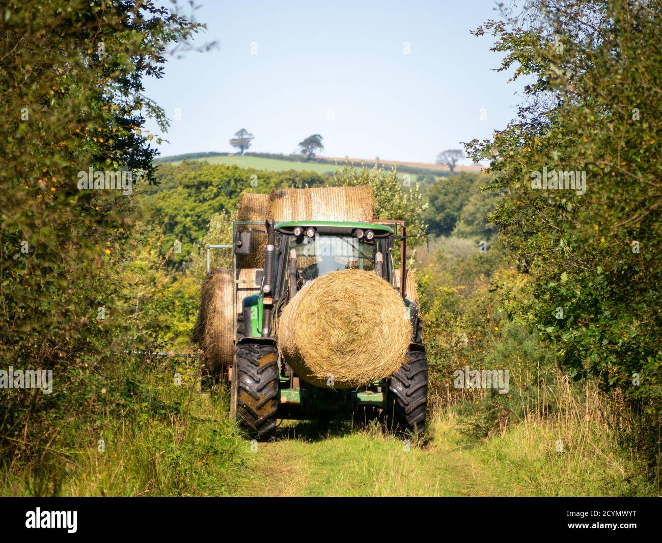Autumn in nature, with tractor. Devon, UK. Hay bales. Stock Photo