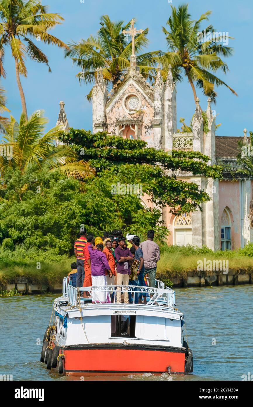 Small tourist boat with Indian passengers about to visit an old church on one of the popular backwater cruises; Alappuzha (Alleppey), Kerala, India Stock Photo