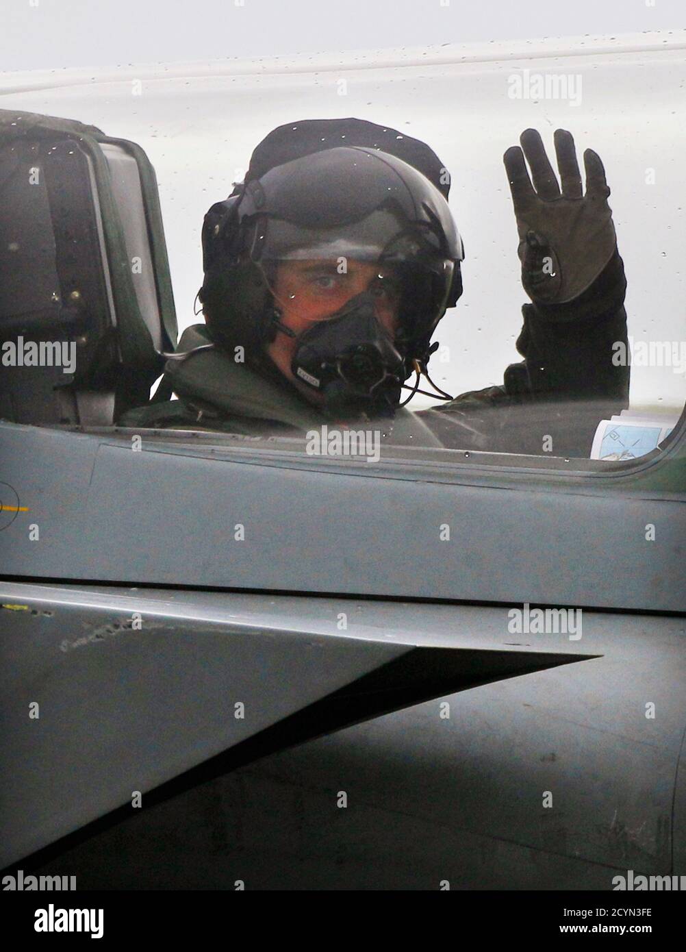 The co-pilot of a Royal Air Force Tornado jet waves to journalists before take off from RAF Lossiemouth base in Moray, northern Scotland October 19, 2010. Britain will unveil on Tuesday its first comprehensive review of the armed forces since 1998, a step the government says will prepare the military for the future but which critics say will usher in only spending cuts.  REUTERS/David Moir (BRITAIN - Tags: POLITICS MILITARY CIVIL UNREST) Stock Photo