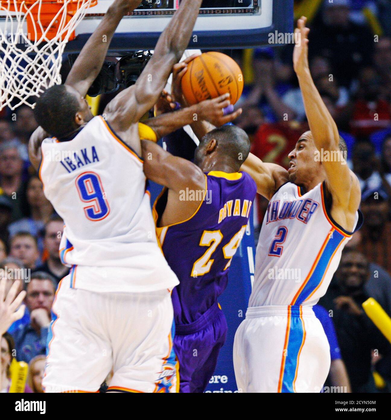 Oklahoma City Thunder center Serge Ibaka of Congo fouls Los Angeles Lakers  guard Kobe Bryant (C) as Thunder guard Thabo Sefolosha (R) of Switzerland  defends in the second half of their NBA