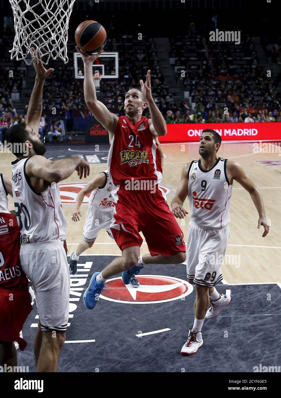 Olympiakos' Matt Lojeski (C) goes up for a basket between Real Madrid's  Felipe Reyes (R) and Ioannis Bourousis during their Euroleague Final Four  final basketball game in Madrid, Spain, May 17, 2015.