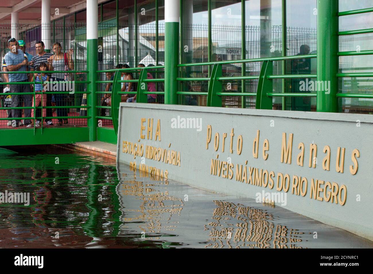People observe the historic water line marker, that shows the current level  of the Rio Negro, one of the two main tributaries of the Amazon, above the  record set in 2009, in