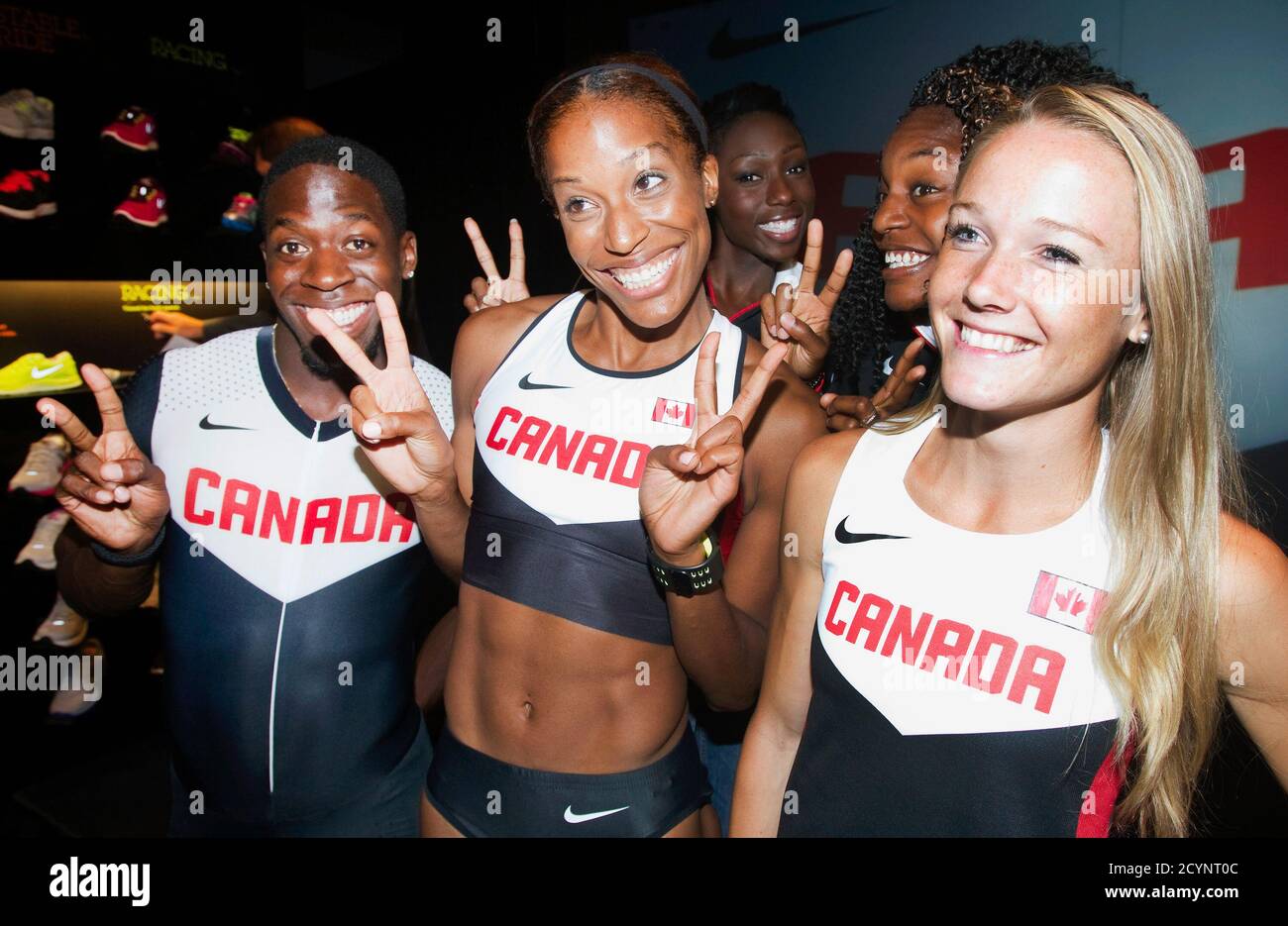 Canadian Olympic athletes Phylicia George (C), Justyn Warner (L) and Sarah  Wells (R) gesture at reporters along with other Olympic athletes at a press  conference held by Nike and Athletics Canada to