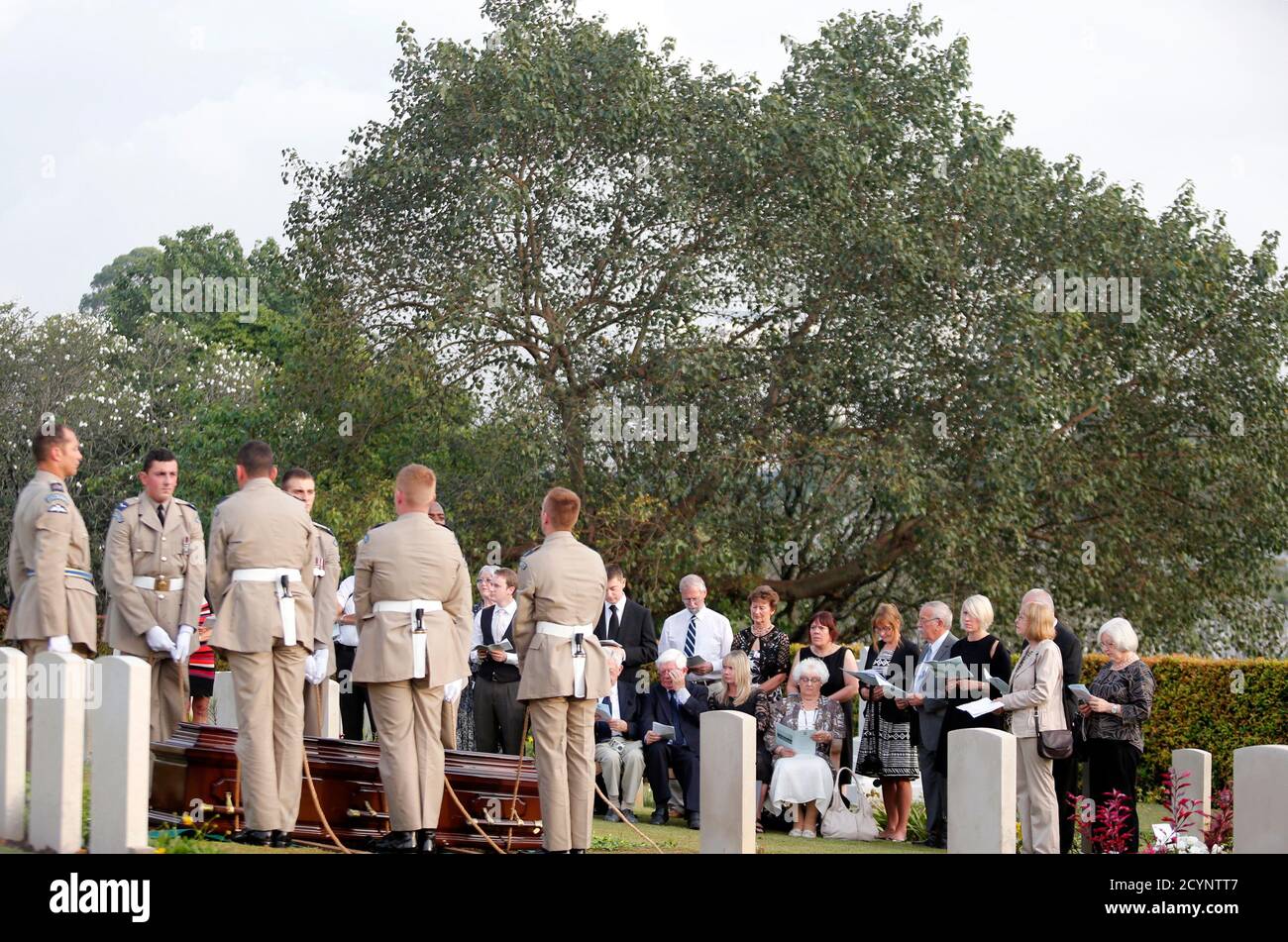 Family Members Of A British Royal Air Force Crew Which Died In An Aircraft Crash During World War Ii Recite Prayers During A Reburial Ceremony At The Commonwealth War Grave Cemetery In