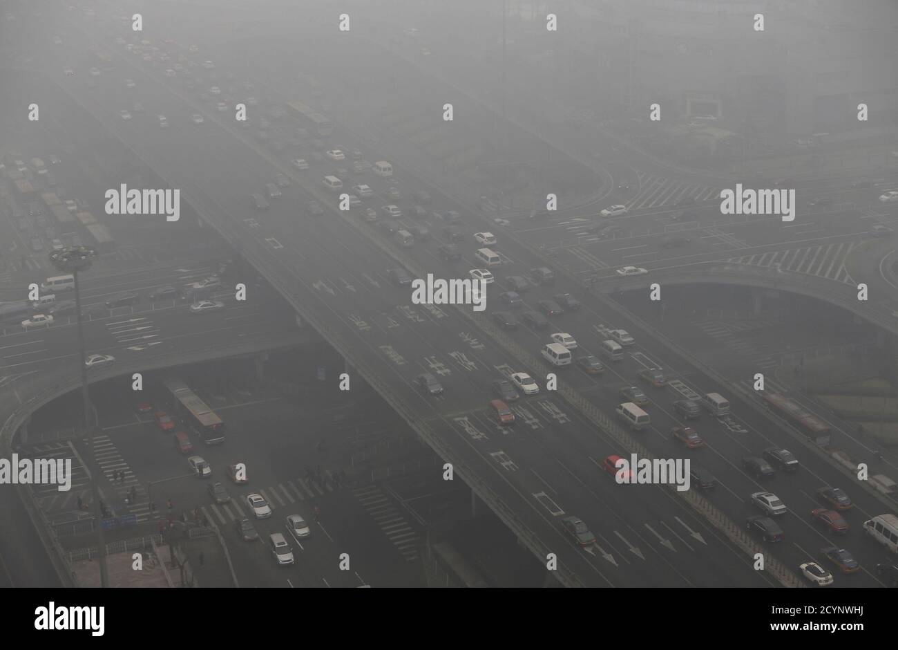 Cars drive on and under Guomao Bridge on a heavy hazy day in Beijing January 29, 2013. The search for culprits behind the rancid haze enveloping China's capital has turned a spotlight on the country's two largest oil companies and their resistance to tougher fuel standards. Picture taken January 29, 2013. REUTERS/Jason Lee (CHINA - Tags: TRANSPORT ENVIRONMENT BUSINESS ENERGY POLITICS) Stock Photo