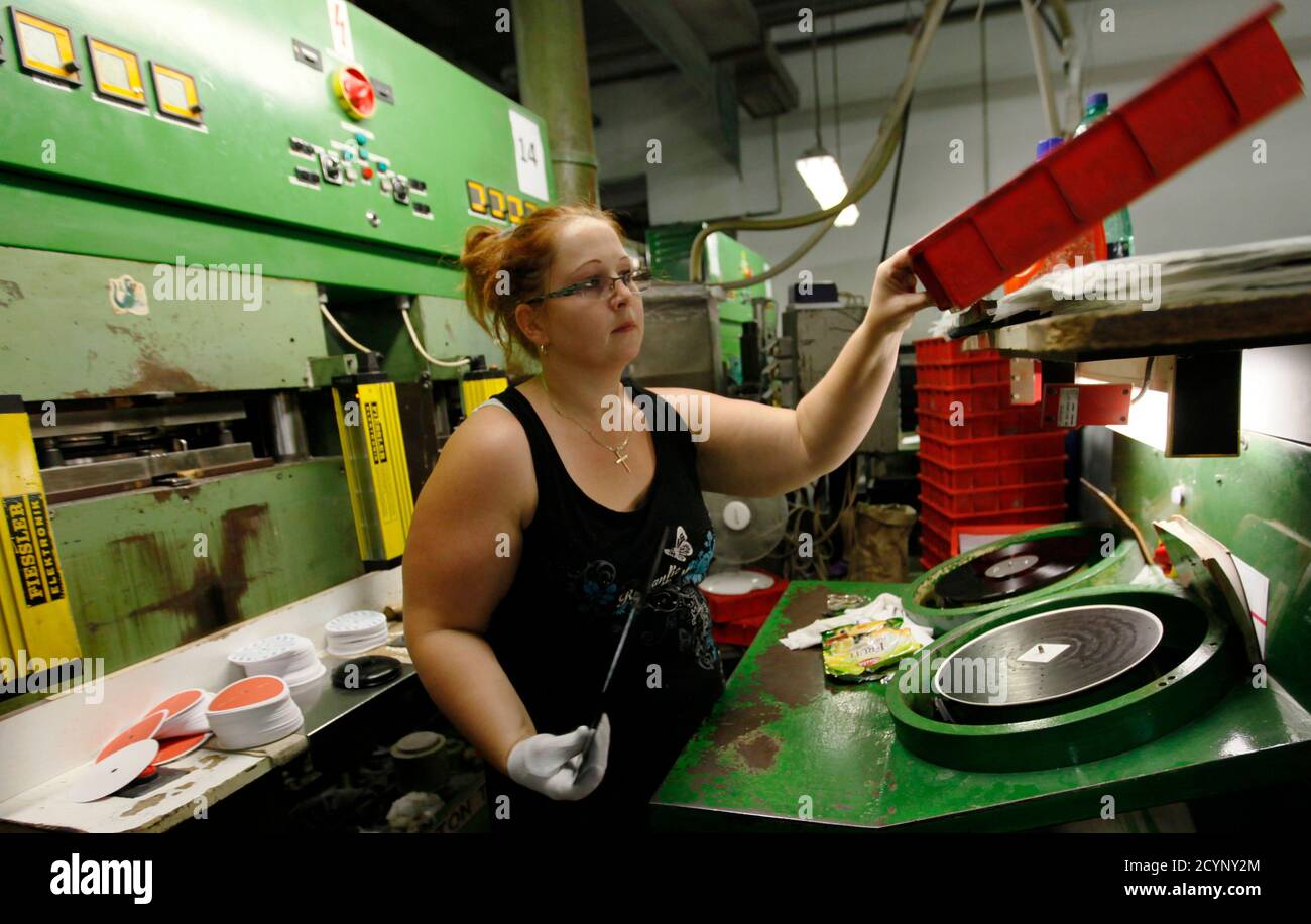 Employee Helena Zakova works at a press machine as part of the creation  process for vinyl records at the GZ Media factory in Lodenice August 1,  2013. With 7 million records made
