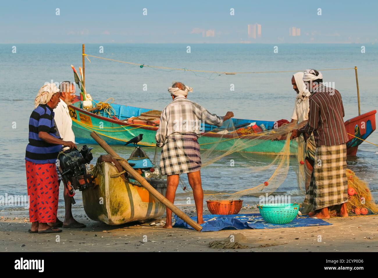 life of traditional fishing people in Kerala, wooden fisherman boat,  fisherman throwing the net in the seashore, fisherman repairs fishing net  Stock Photo - Alamy