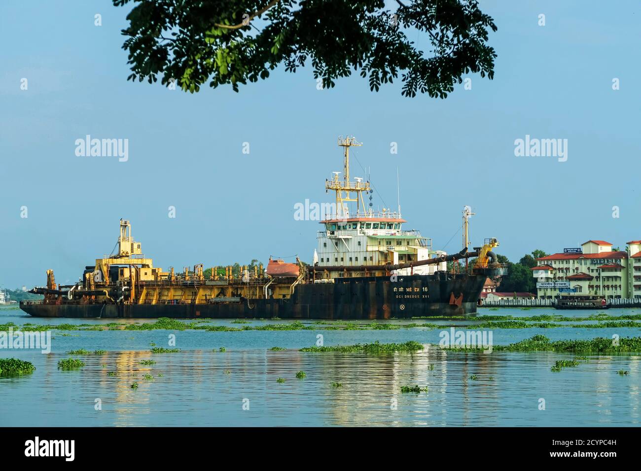 Dredger ship on Lake Vembanad passes Fort Cochin waterfront. Kochi is a major port & Vallarpadam Terminal is nearby; Fort Cochin, Kochi, Kerala, India Stock Photo