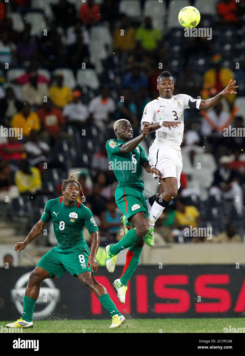 Ghana's Asamoah Gyan (R) is challenged by Burkina Faso's Anthony Annan (C) as Paul Koulibaly looks on during their African Cup of Nations (AFCON 2013) semi-final soccer match at the Mbombela Stadium in Nelspruit February 6, 2013. REUTERS/Thomas Mukoya (SOUTH AFRICA - Tags: SPORT SOCCER TPX IMAGES OF THE DAY) Stock Photo