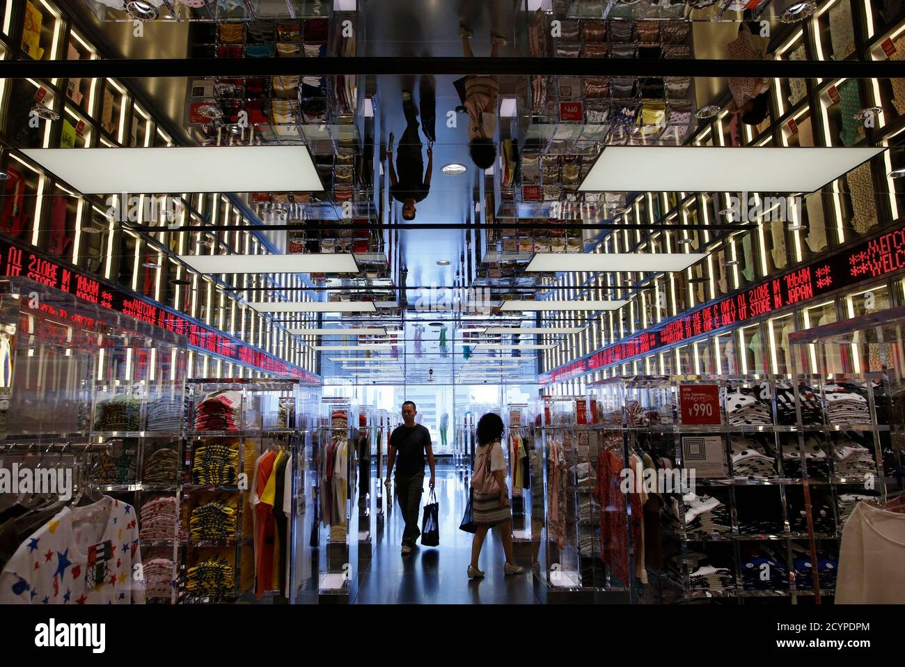 Shoppers walk in Fast Retailing's Uniqlo casual clothing store in Tokyo  July 11, 2013. Asia's biggest retailer Fast Retailing Co Ltd left its  profit forecast for the year to August unchanged as