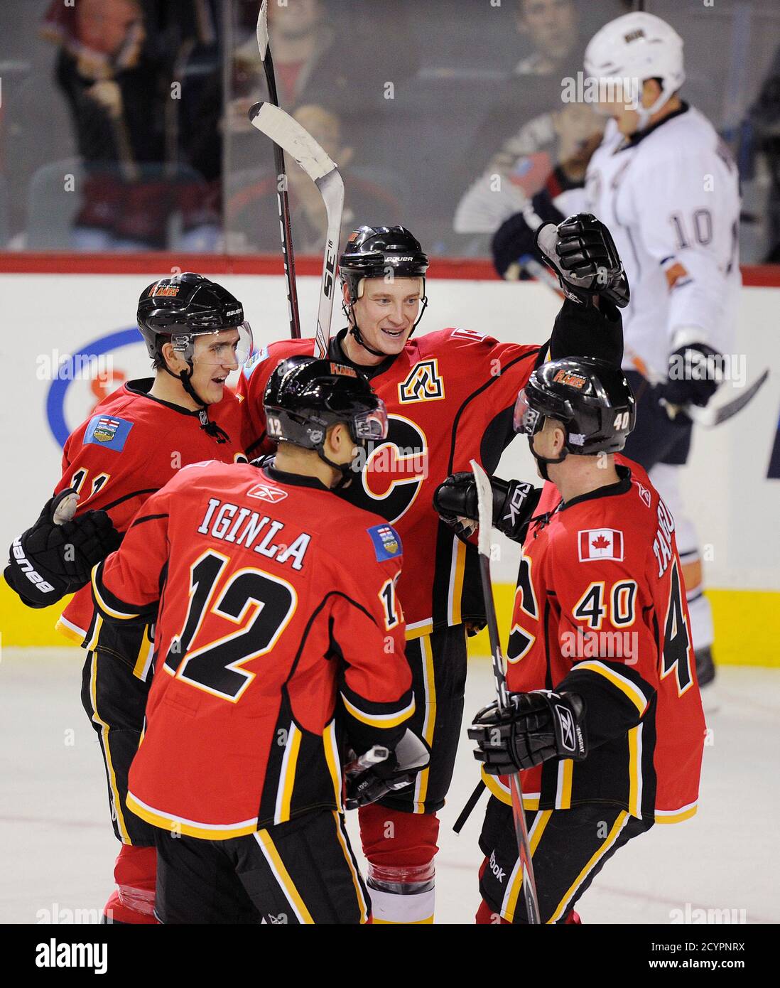 Calgary Flames' Jay Bouwmeester (C) celebrates his first goal of the season  with teammates Mikael Backlund (11), Jarome Iginla (12), and Alex Tanguay  (40) while Edmonton Oilers' Shawn Horcoff skates in the