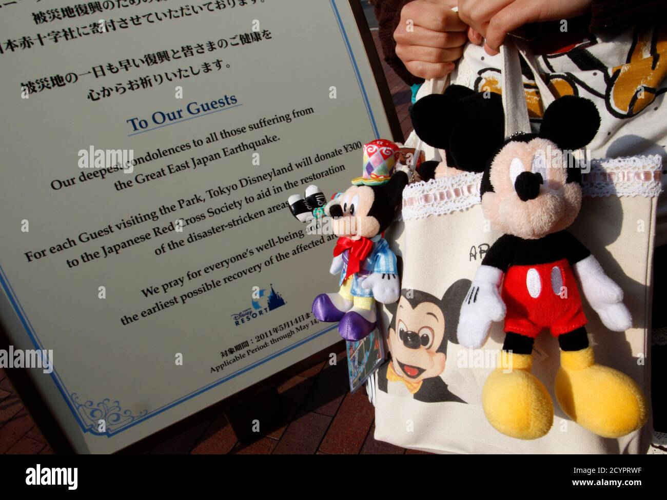 A Disney Character Fan Stands Next To An Announcement Board At Tokyo Disneyland In Urayasu East Of Tokyo April 15 11 Tokyo Disneyland Reopened Its Popular Theme Park On Friday After A