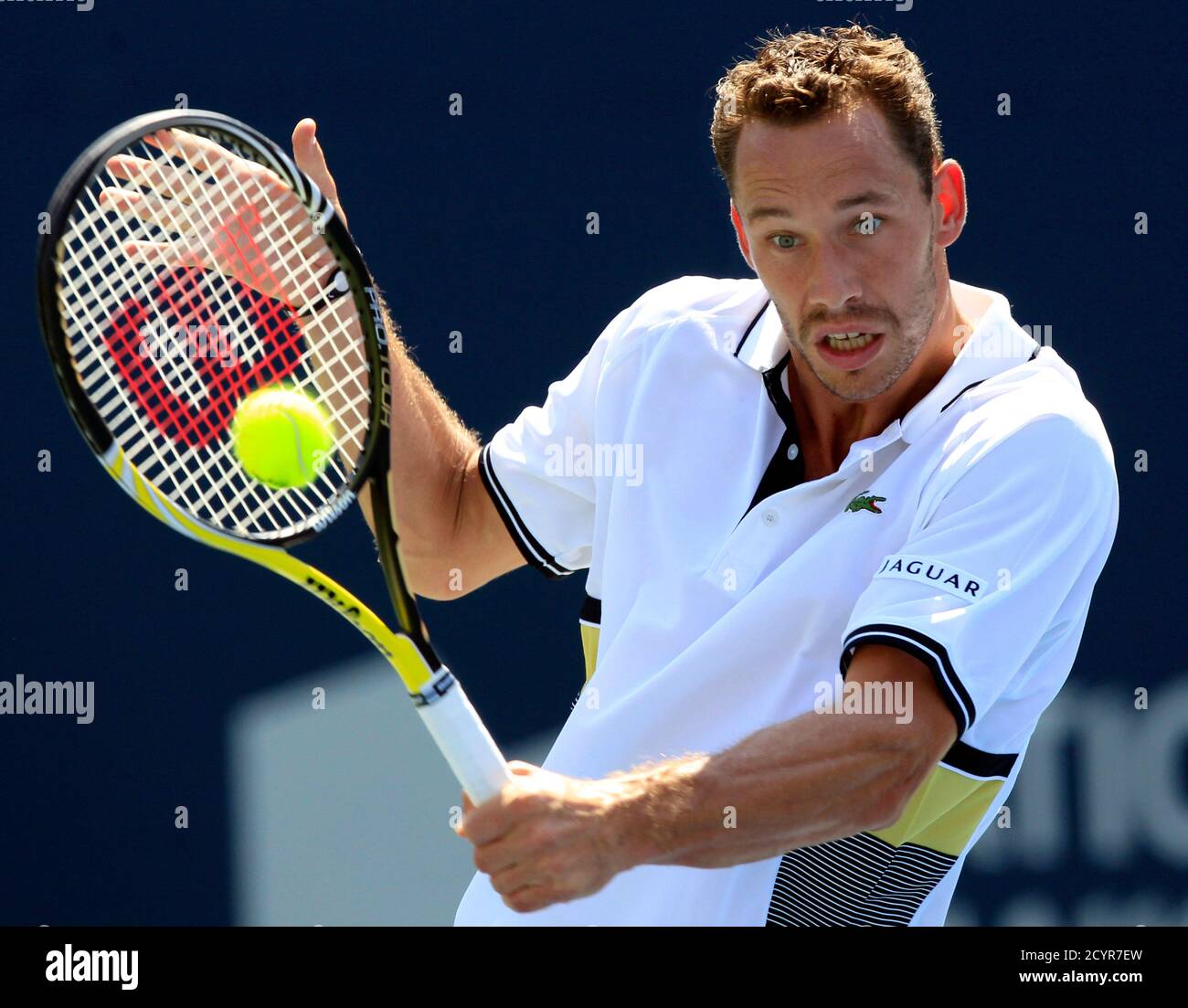 Michael Llodra of France returns a backhand against Roger Federer of  Switzerland during their match at