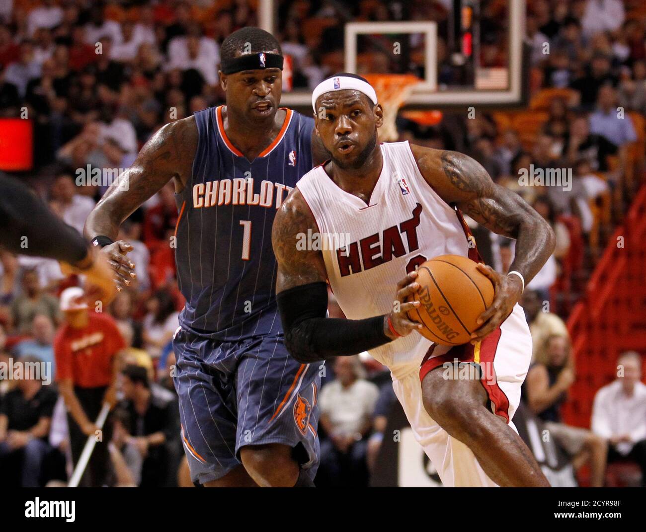 Miami Heat forward LeBron James (R) drives downcourt as Charlotte
