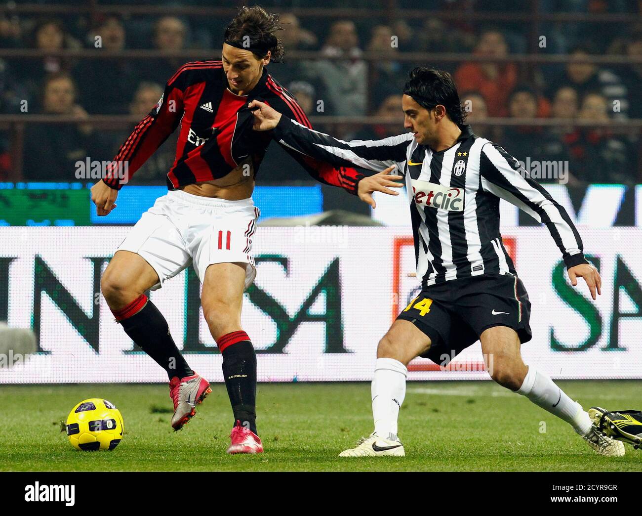 AC Milan's Zlatan Ibrahimovic (L) is challenged by Juventus' Alberto  Aquilani during their Italian Serie A soccer match at the San Siro stadium  in Milan October 30, 2010. REUTERS/Giampiero Sposito (ITALY -