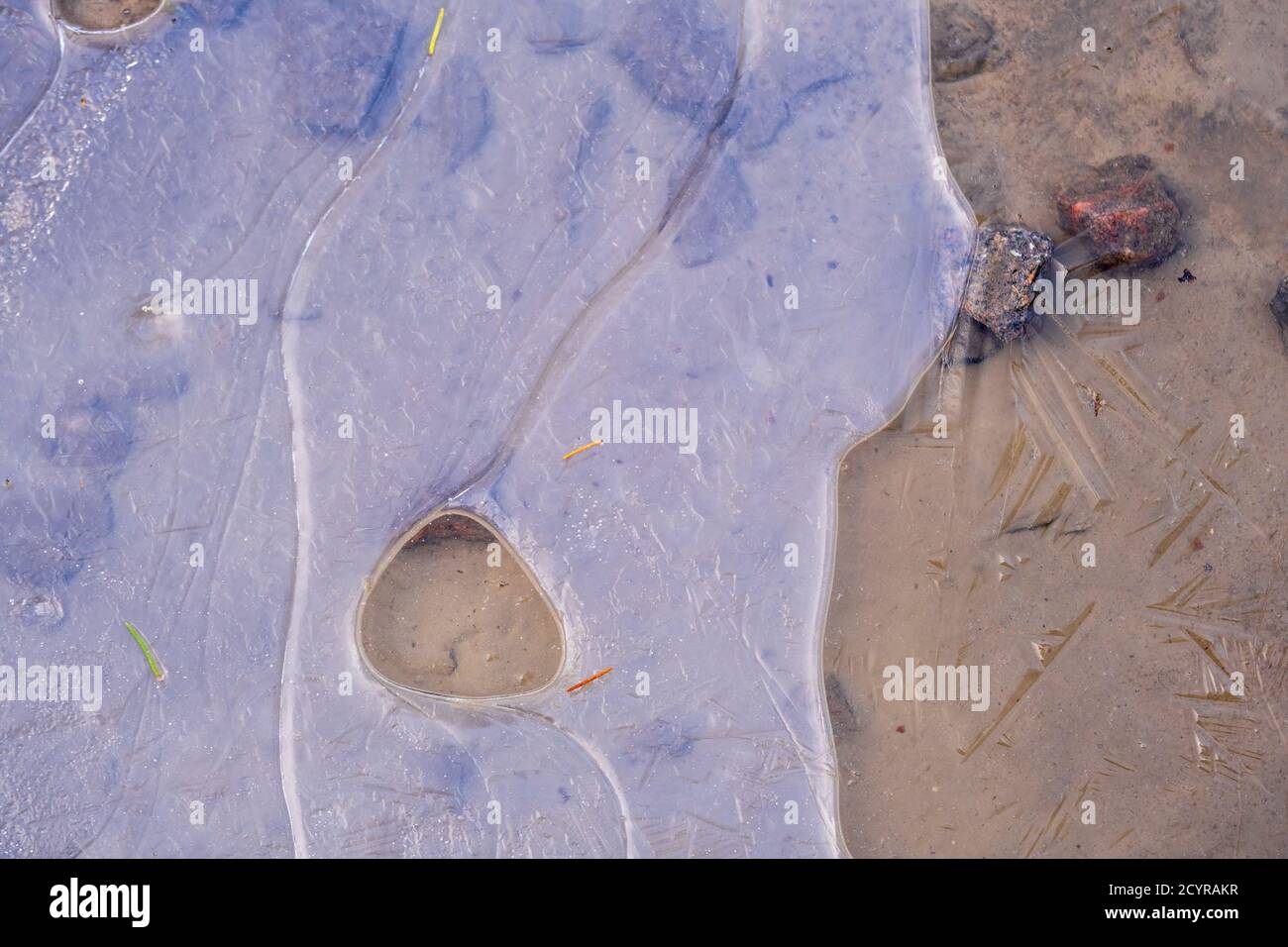 Frozen ice at a sandy beach Stock Photo